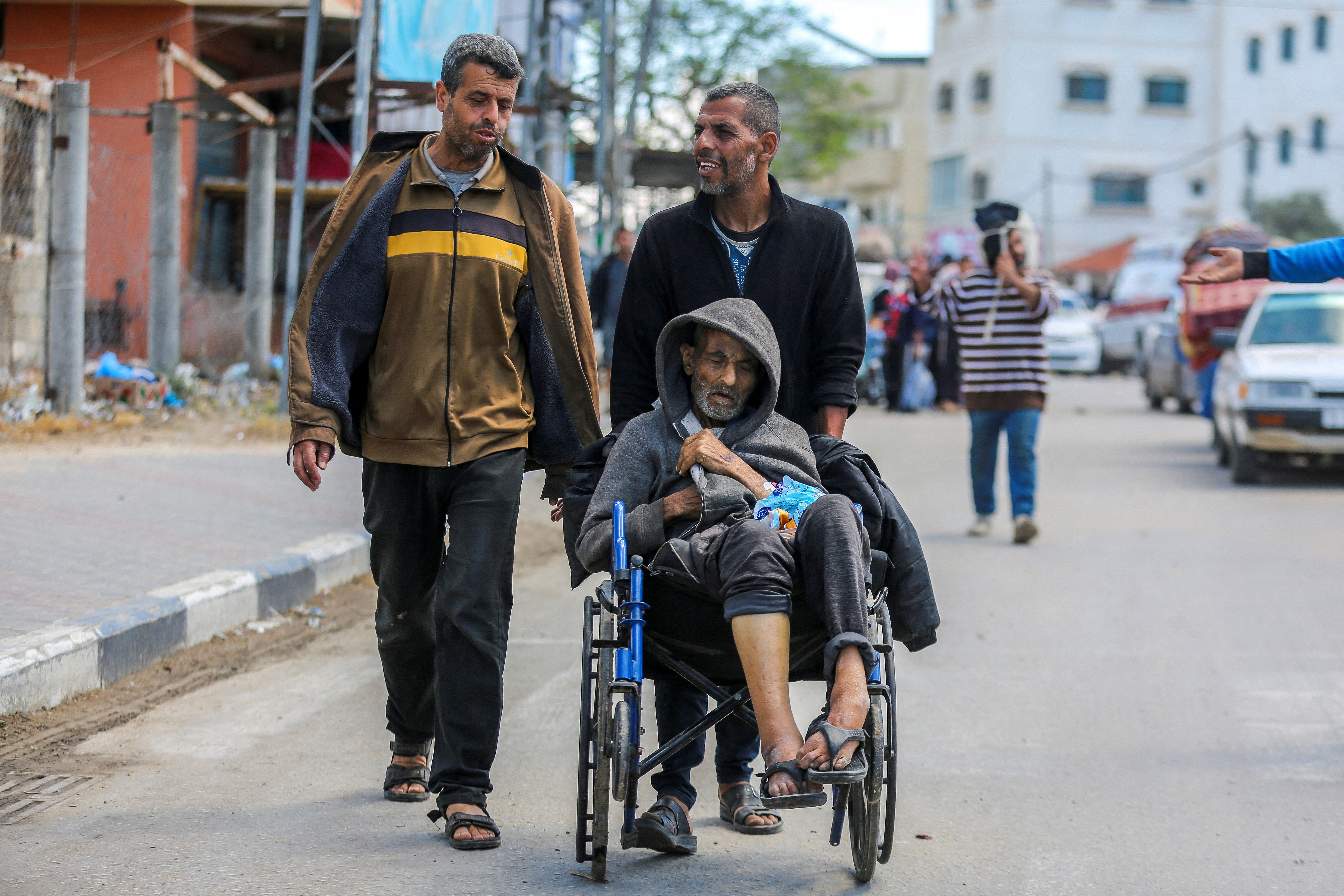 An elderly man is pushed in a wheelchair as Palestinians leave Rafah ahead of a long-anticipated Israeli invasion of the area