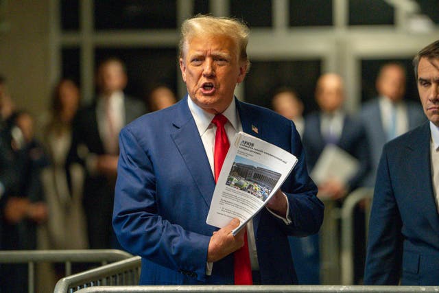 Clutching print outs of news articles, Donald Trump arrives at court on 6 May  2024