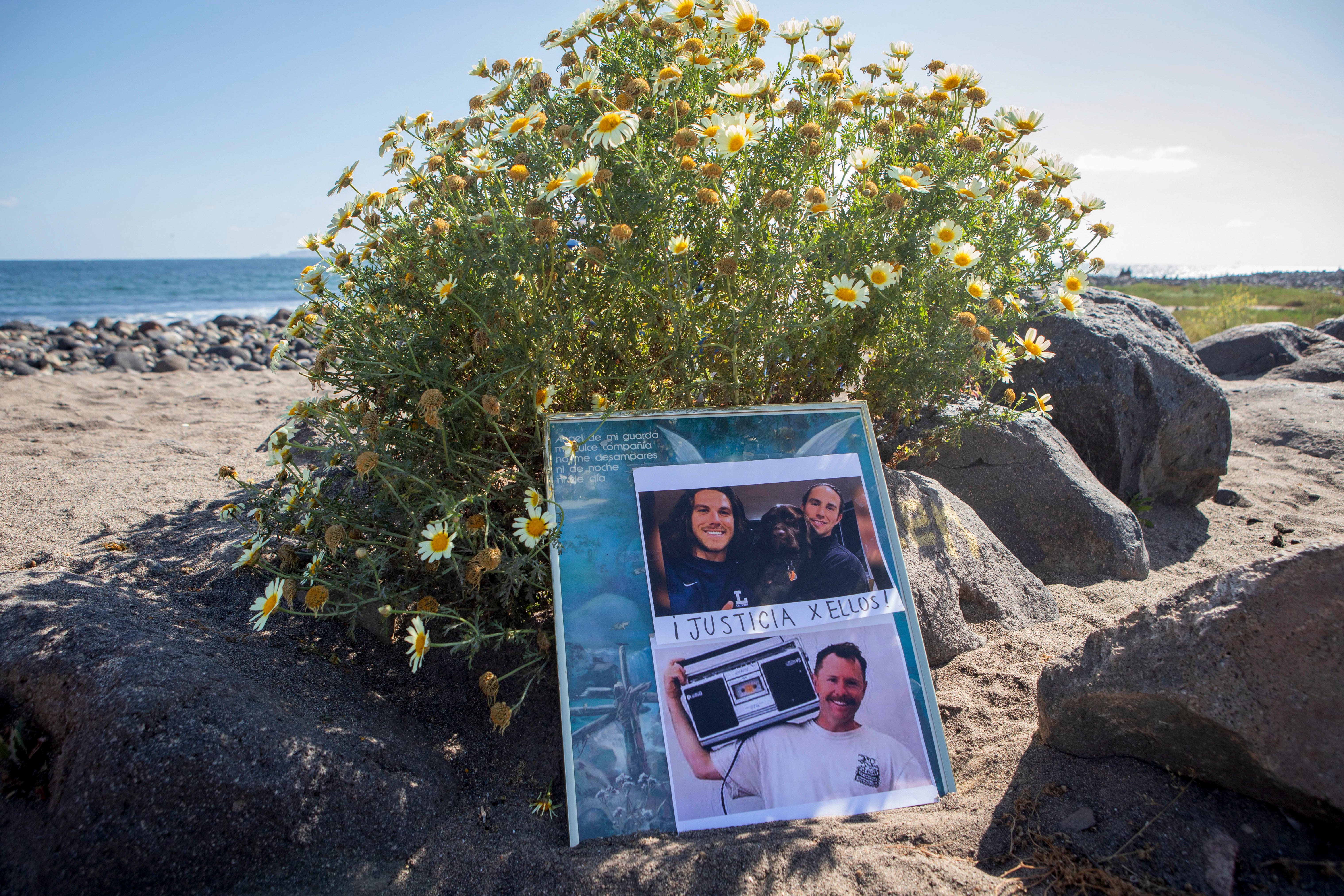 The photos of the foreign surfers who disappeared are placed on the beach in Ensenada, Mexico, on 5 May