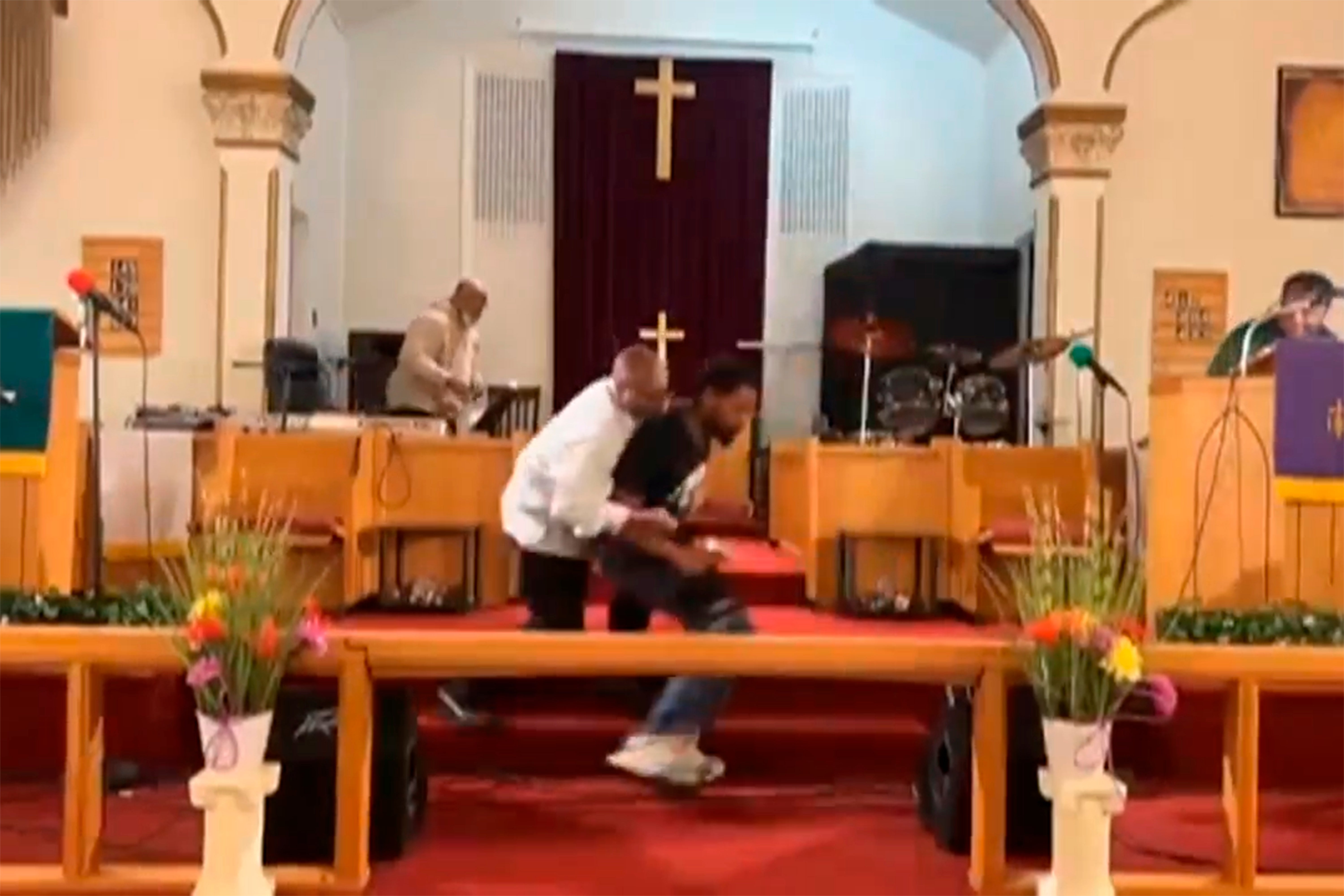 A member of the congregation tackles the gunman to the floor at Jesus’ Dwelling Place Church in North Braddock