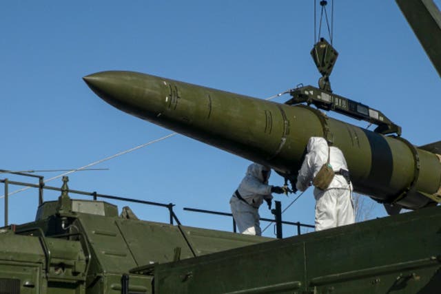 <p>Russian troops load an Iskander ballistic missile onto a mobile launcher in February </p>