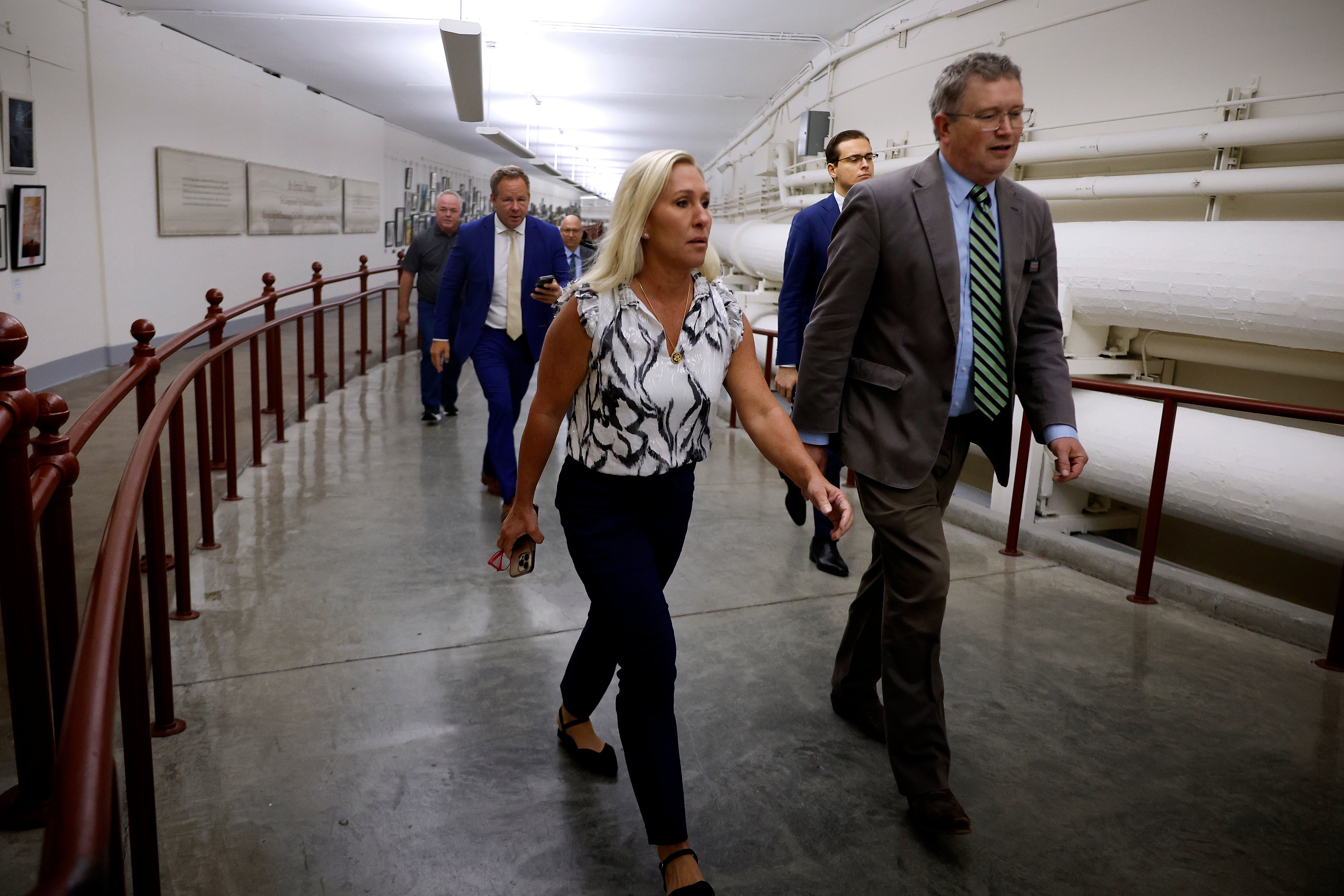 Marjorie Taylor Greene and Thomas Massie walk through the US Capitol to Speaker Mike Johnson’s office on 6 May 2024. Ms Greene is meeting with Mr Johnson on Monday afternoon about her efforts to oust him