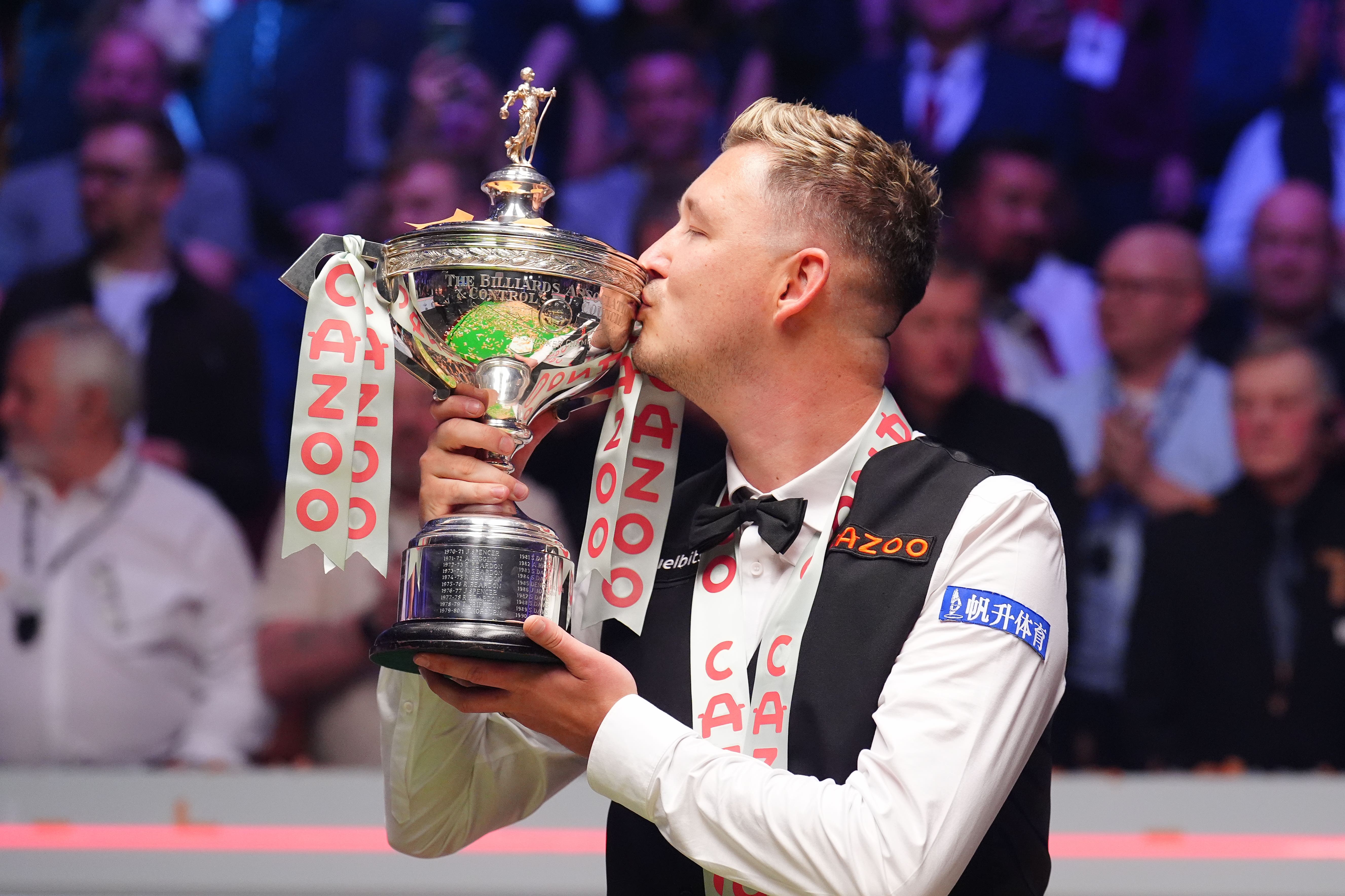 Wilson celebrates with the trophy after winning the world snooker title