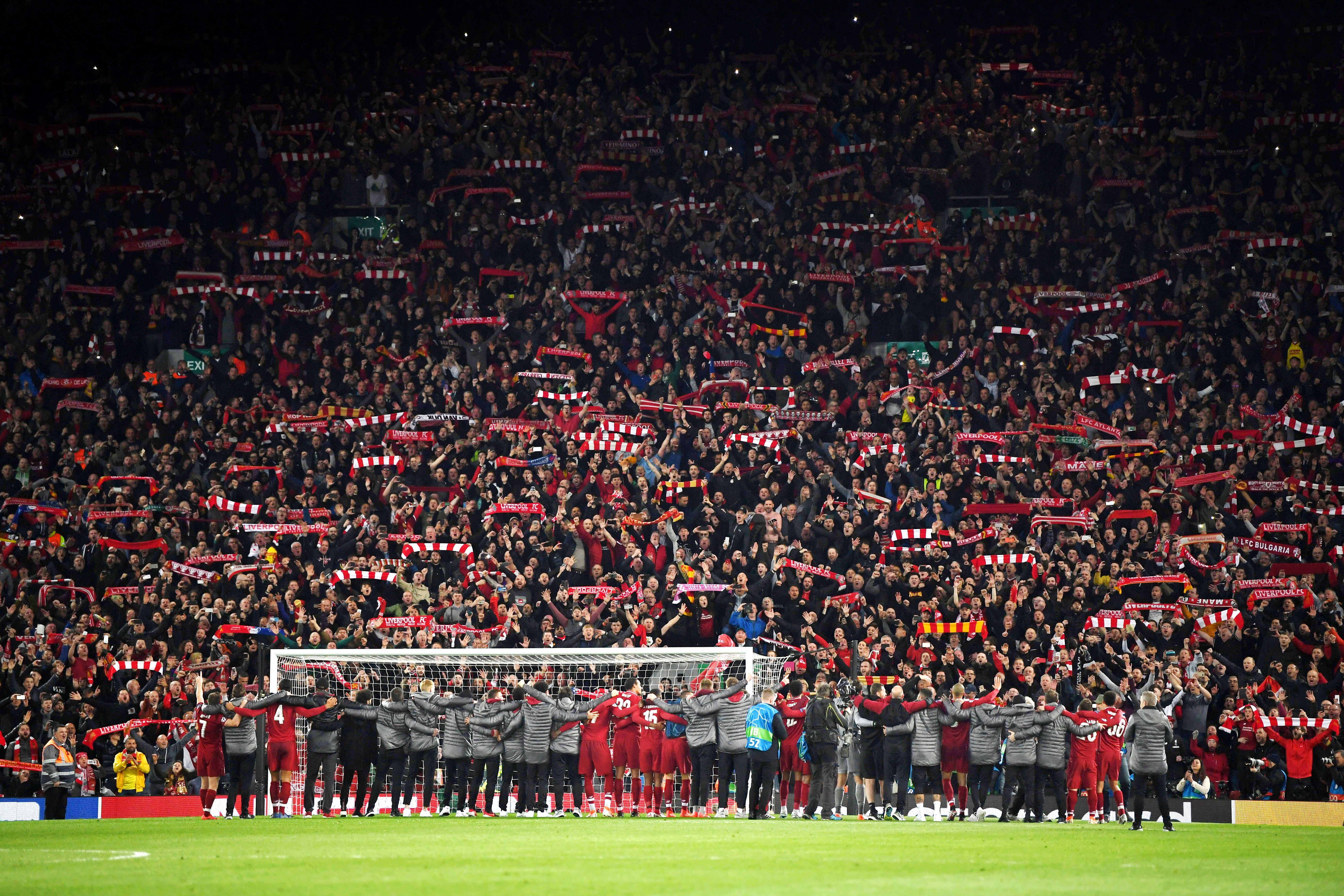 The Liverpool players and staff celebrate with fansa after the match