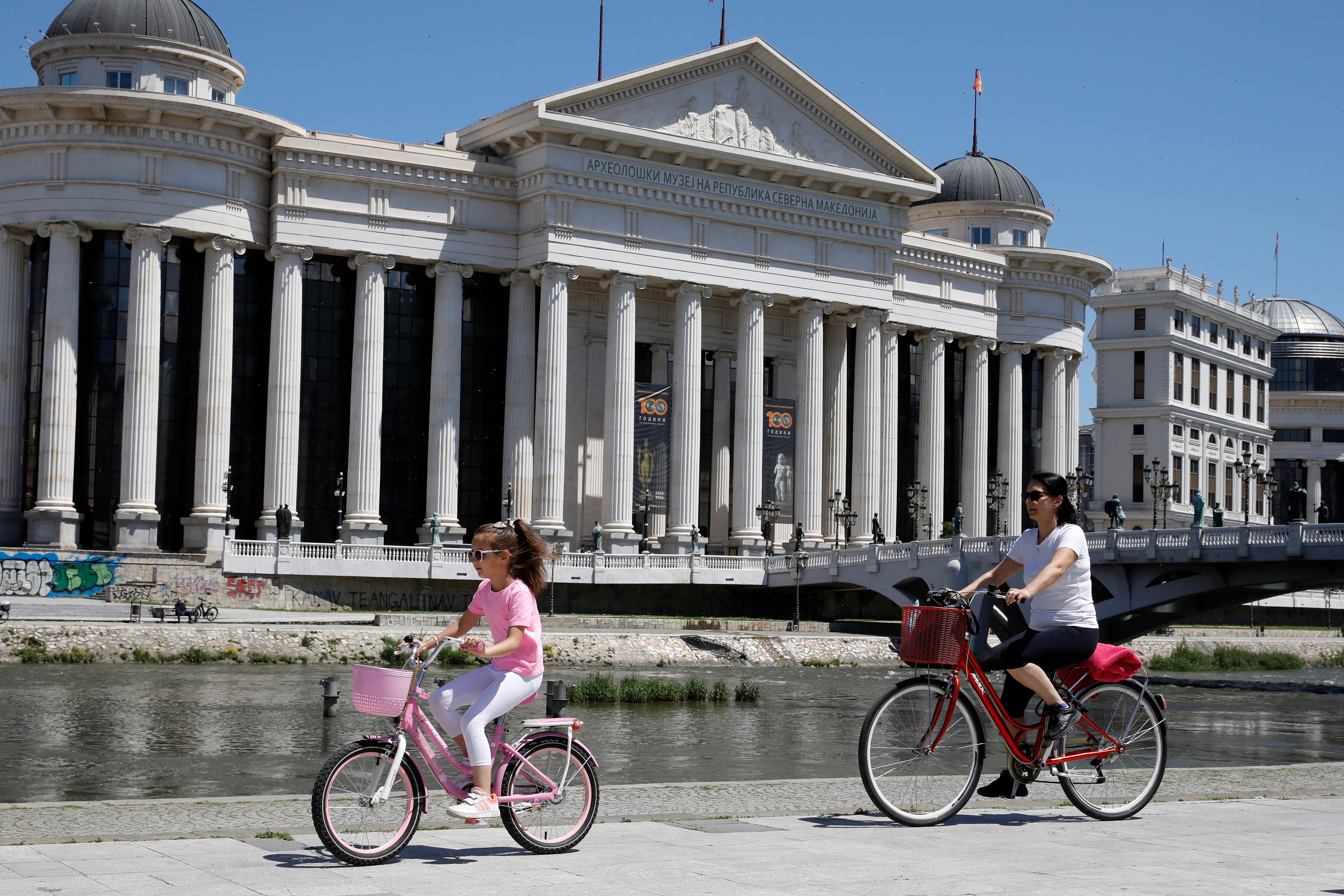 North Macedonia A woman and a girl ride bicycles by Vardar river in downtown Skopje, North Macedonia, on Monday, May 6, 2024