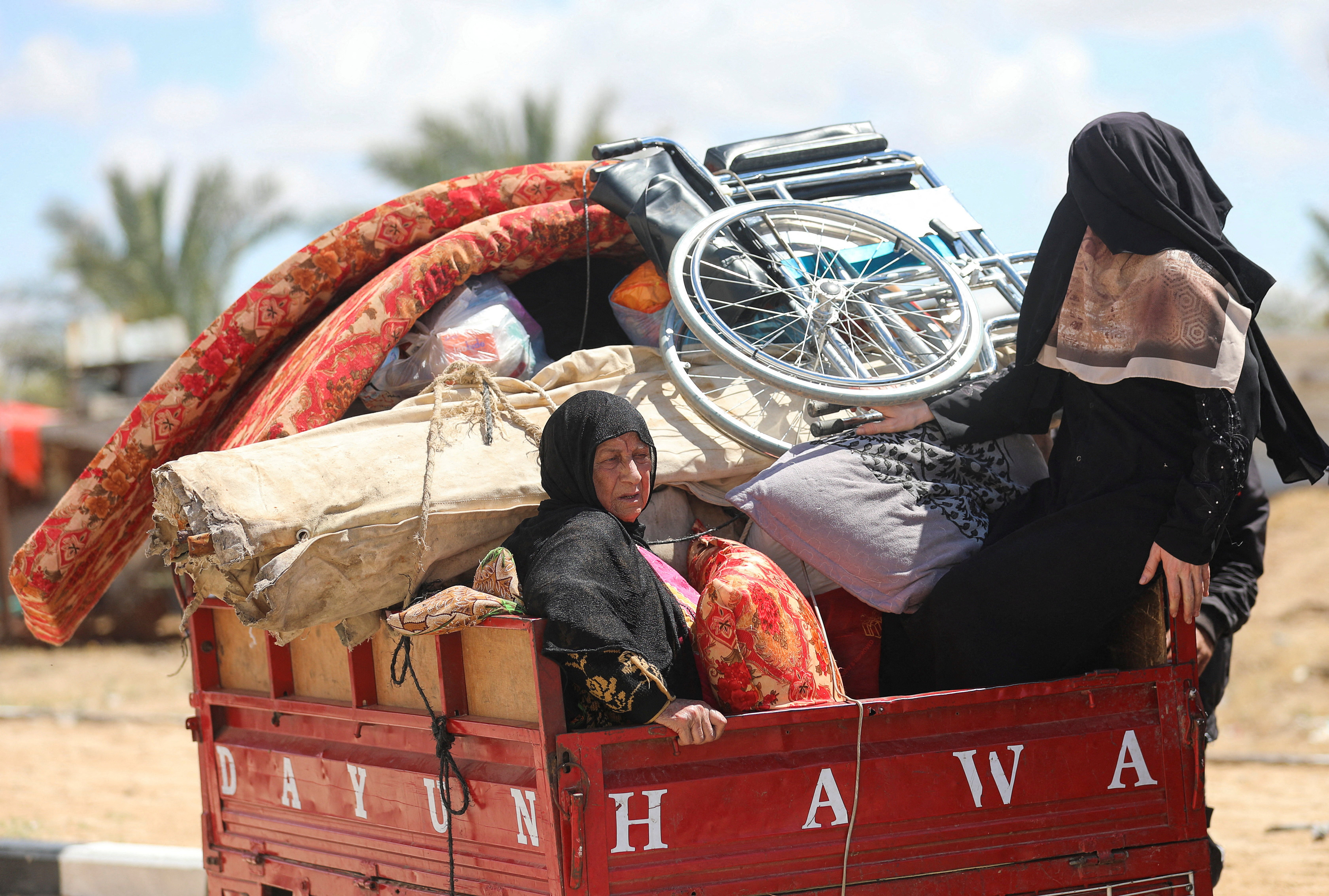 Displaced Palestinians who fled Rafah, ahead of a threatened Israeli assault, travel in Al-Mawasi area, in Khan Younis