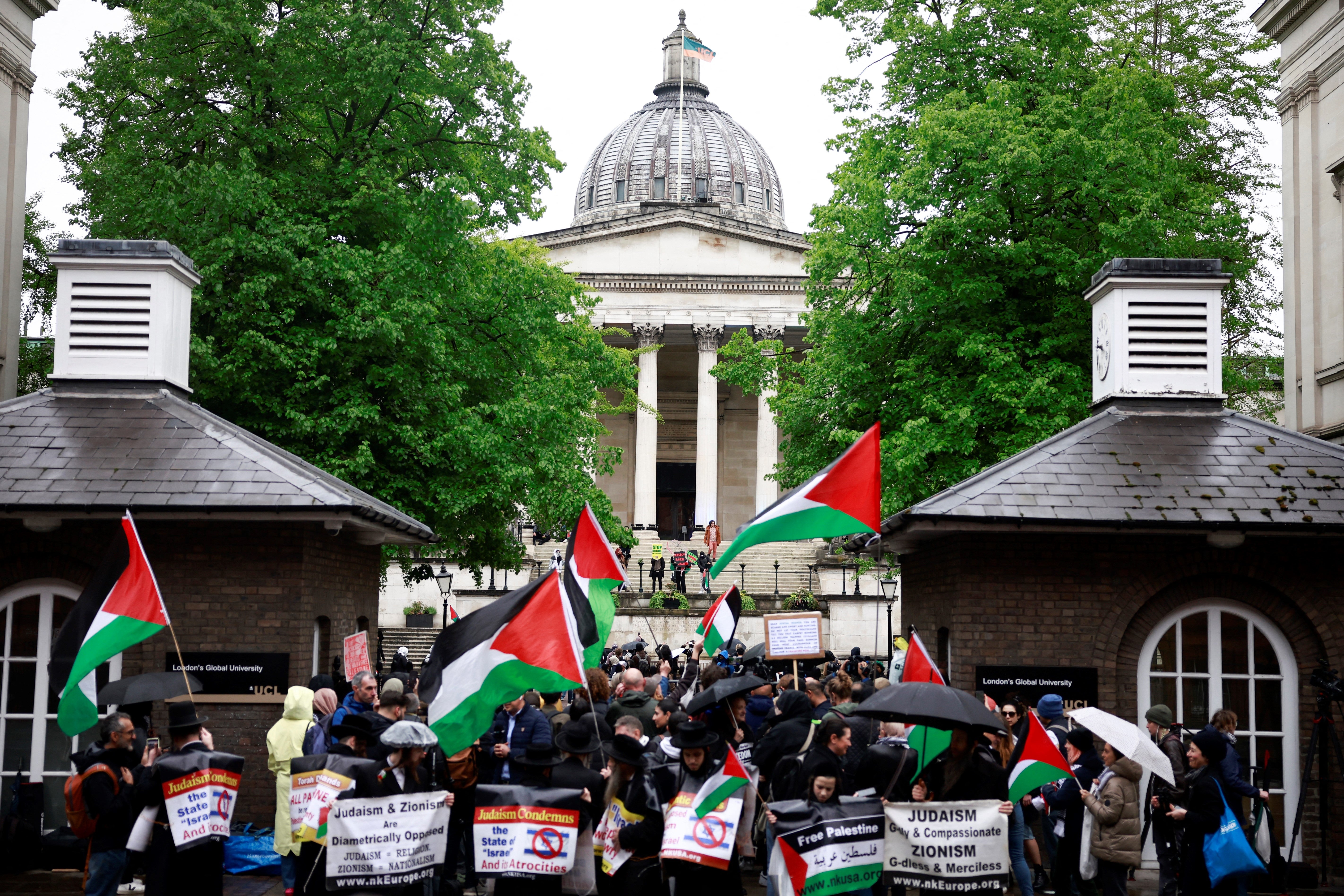 People hold placards and wave Palestinian flags as they take part in a demonstration in support to Palestinian people at University College London