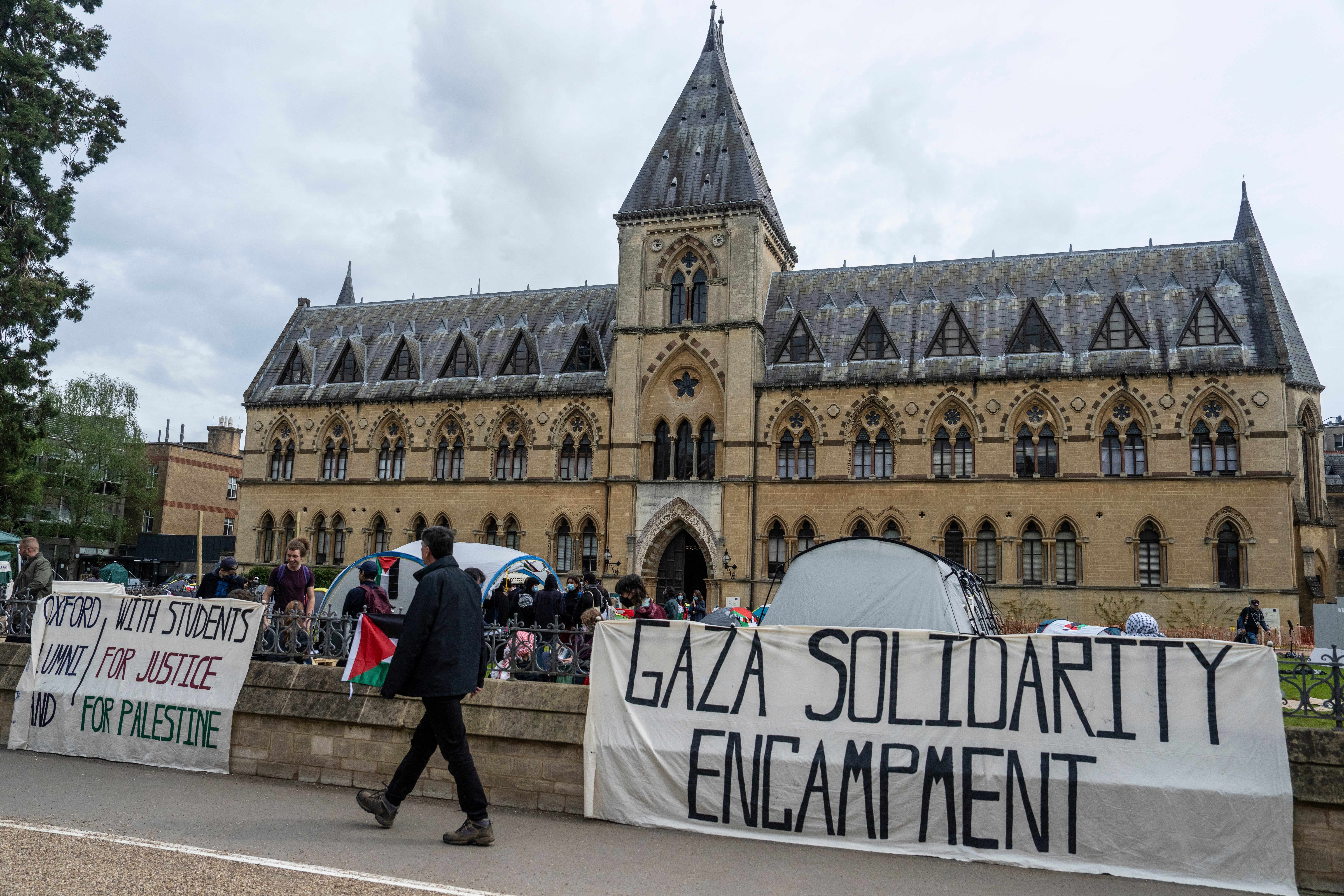 People walk past a pro-Palestine encampment set up by students at Oxford University