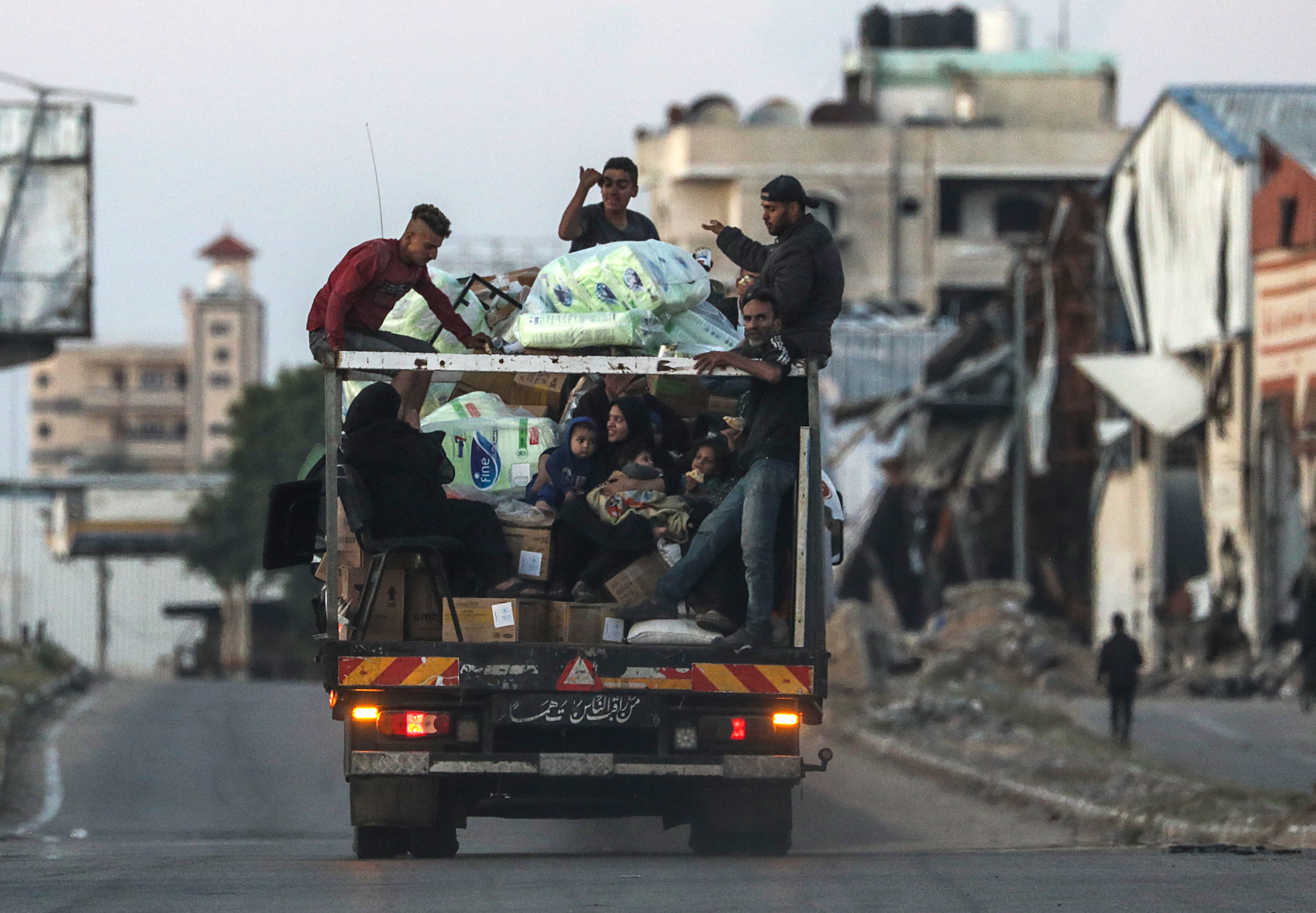 Palestinians can be seen on the back of a van heading out of Rafah