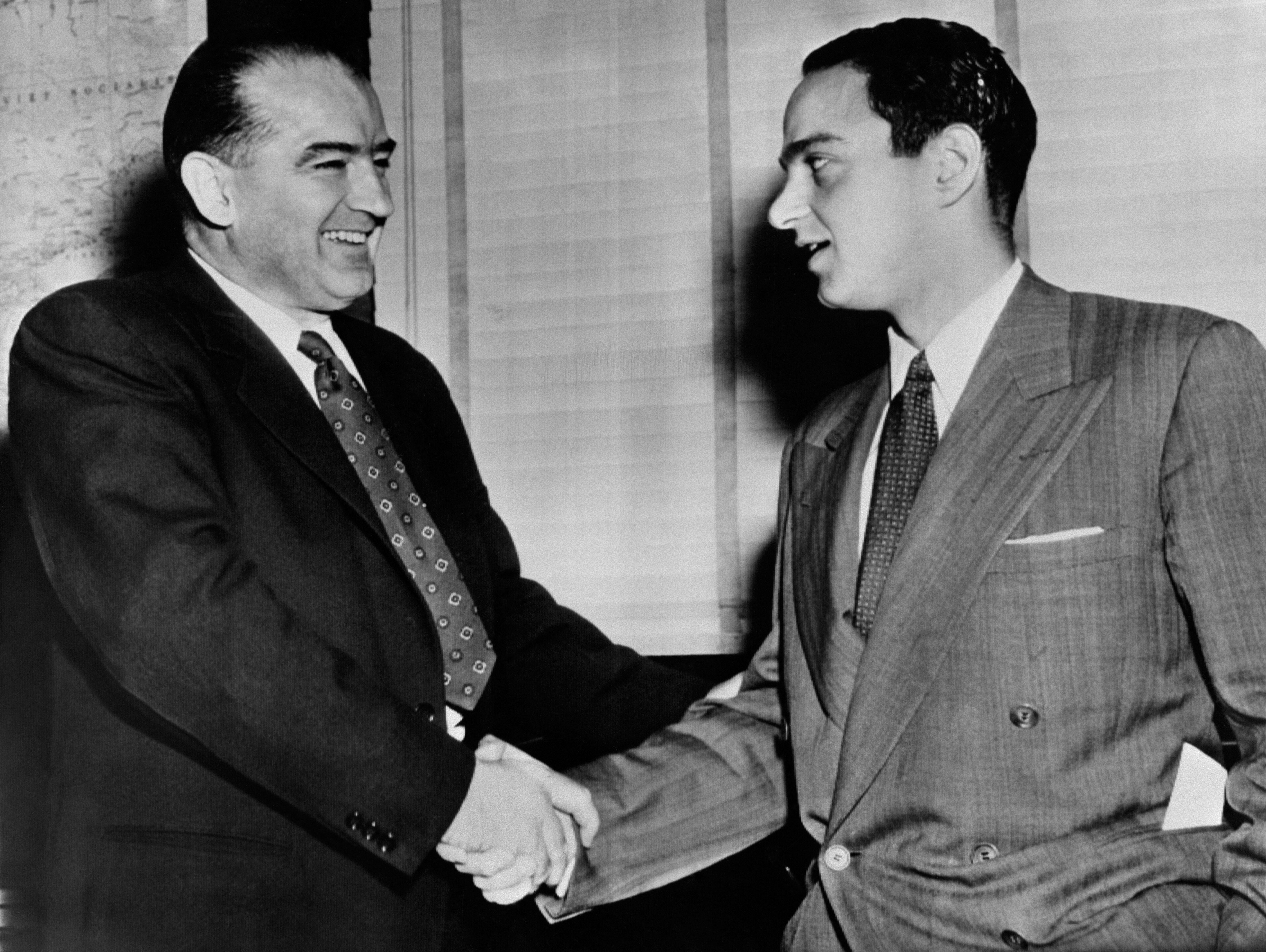 Roy Cohn shakes hands with infamous Sen. Joseph McCarthy; the young and rising New York lawyer served as chief counsel during the infamous anti-Communist hearings and witch-hunts, making him a headline staple