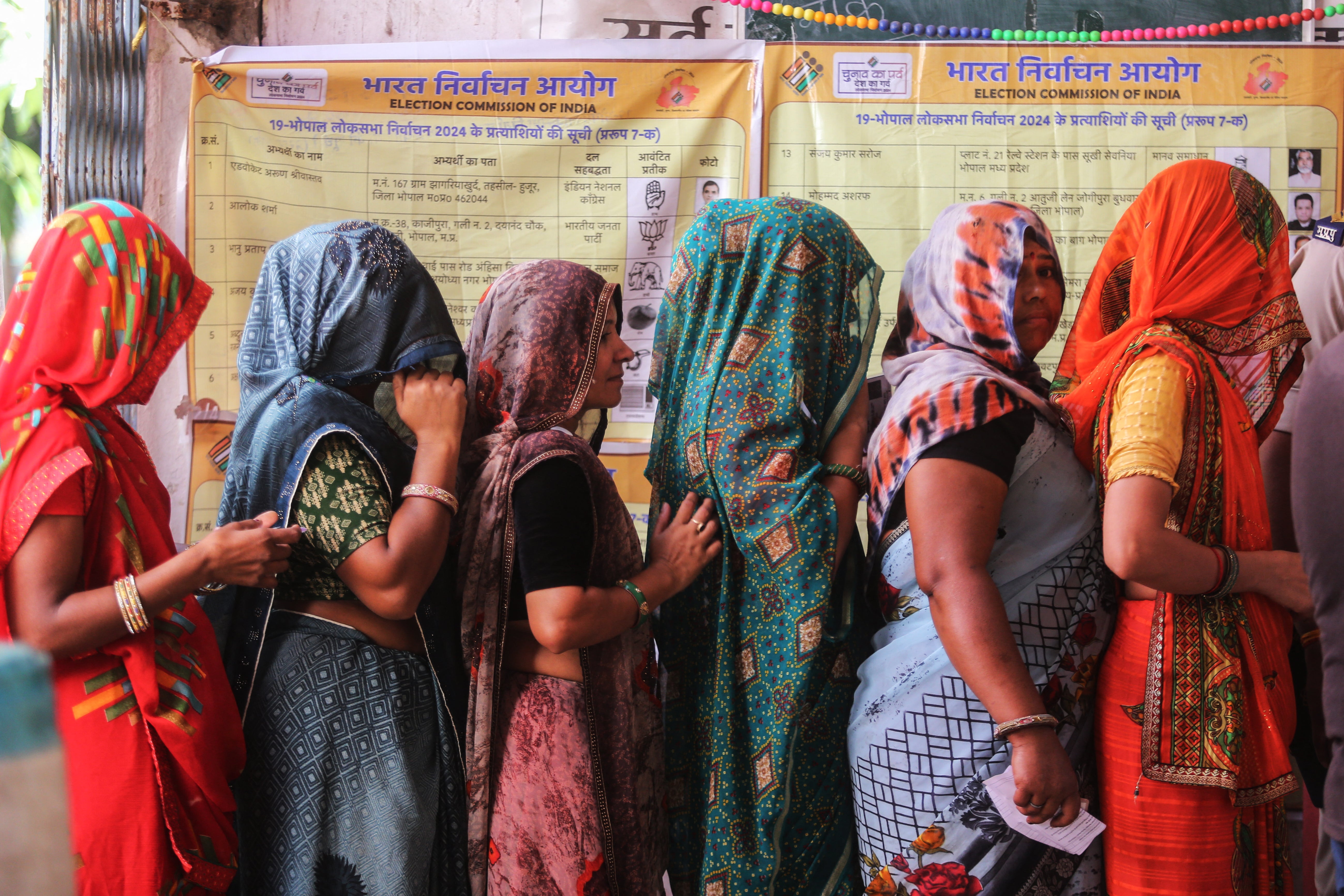 Indians stand in a queue to cast their ballots at a polling station during the third phase of polling in India's general election in Bhopal