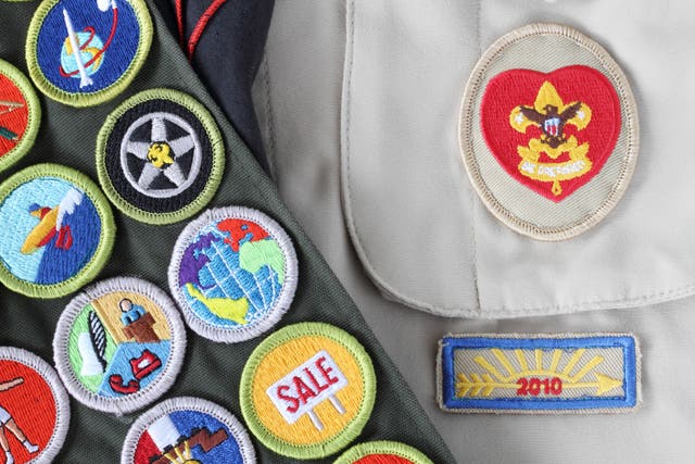 <p>A scout uniform loaded with merit badges </p>