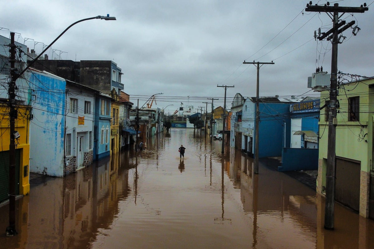 Watch live: Brazilians navigate flooded streets by boat as at least 90 people confirmed dead