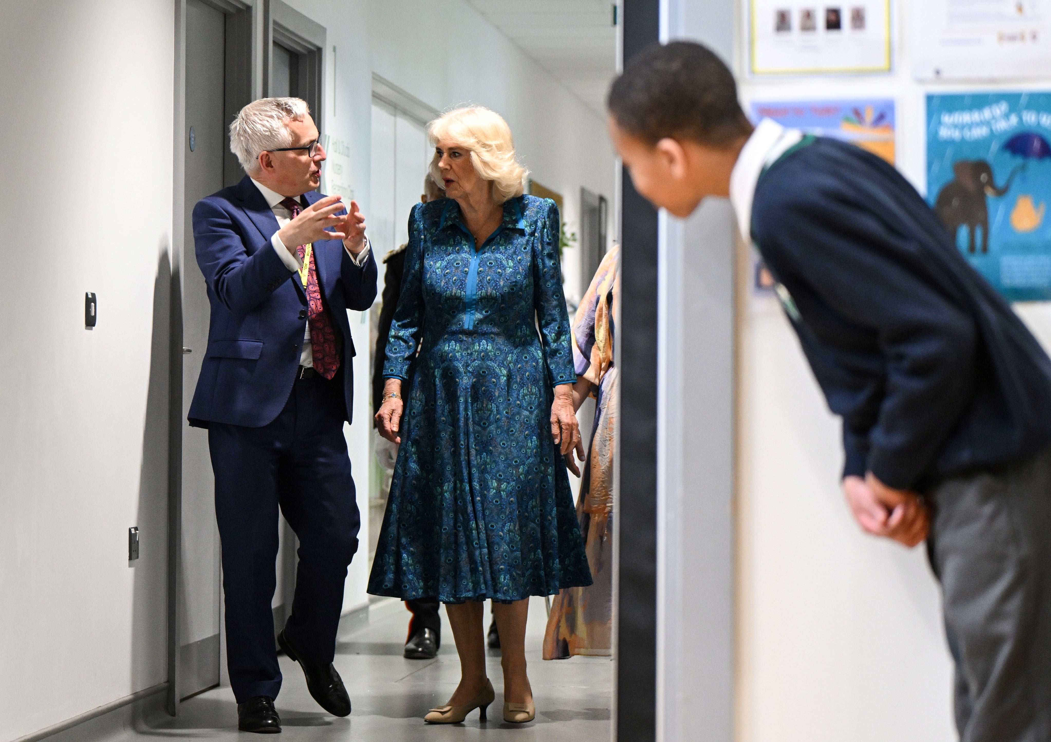 A pupil takes a peak as he waits for Queen Camilla