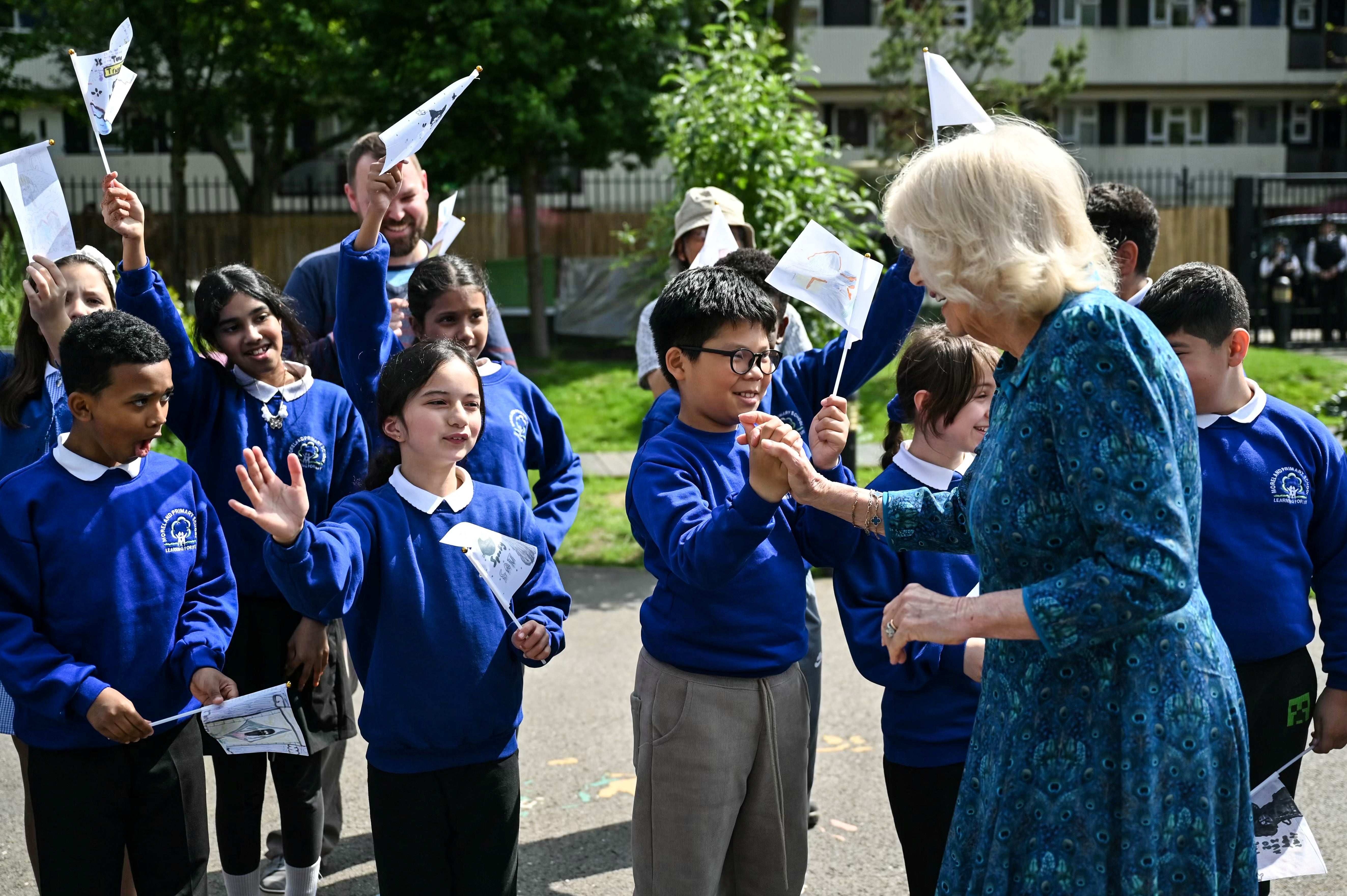 Queen Camilla is greeted by pupils in the courtyard of the school