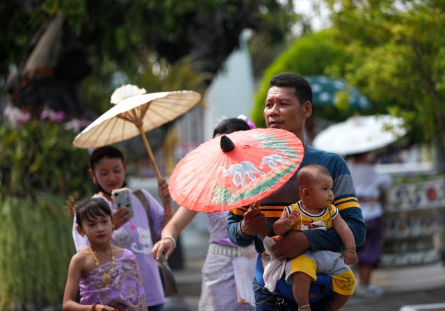 <p>Visitors use umbrellas to protect themselves from sunlight amid hot weather at the Temple of Dawn, or Wat Arun, in Bangkok, Thailand. Extremely hot weather has killed 38 people  in Thailand this summer. </p>