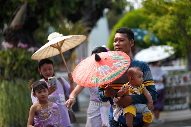 <p>Visitors use umbrellas to protect themselves from sunlight amid hot weather at the Temple of Dawn, or Wat Arun, in Bangkok, Thailand. Extremely hot weather has killed 38 people  in Thailand this summer. </p>