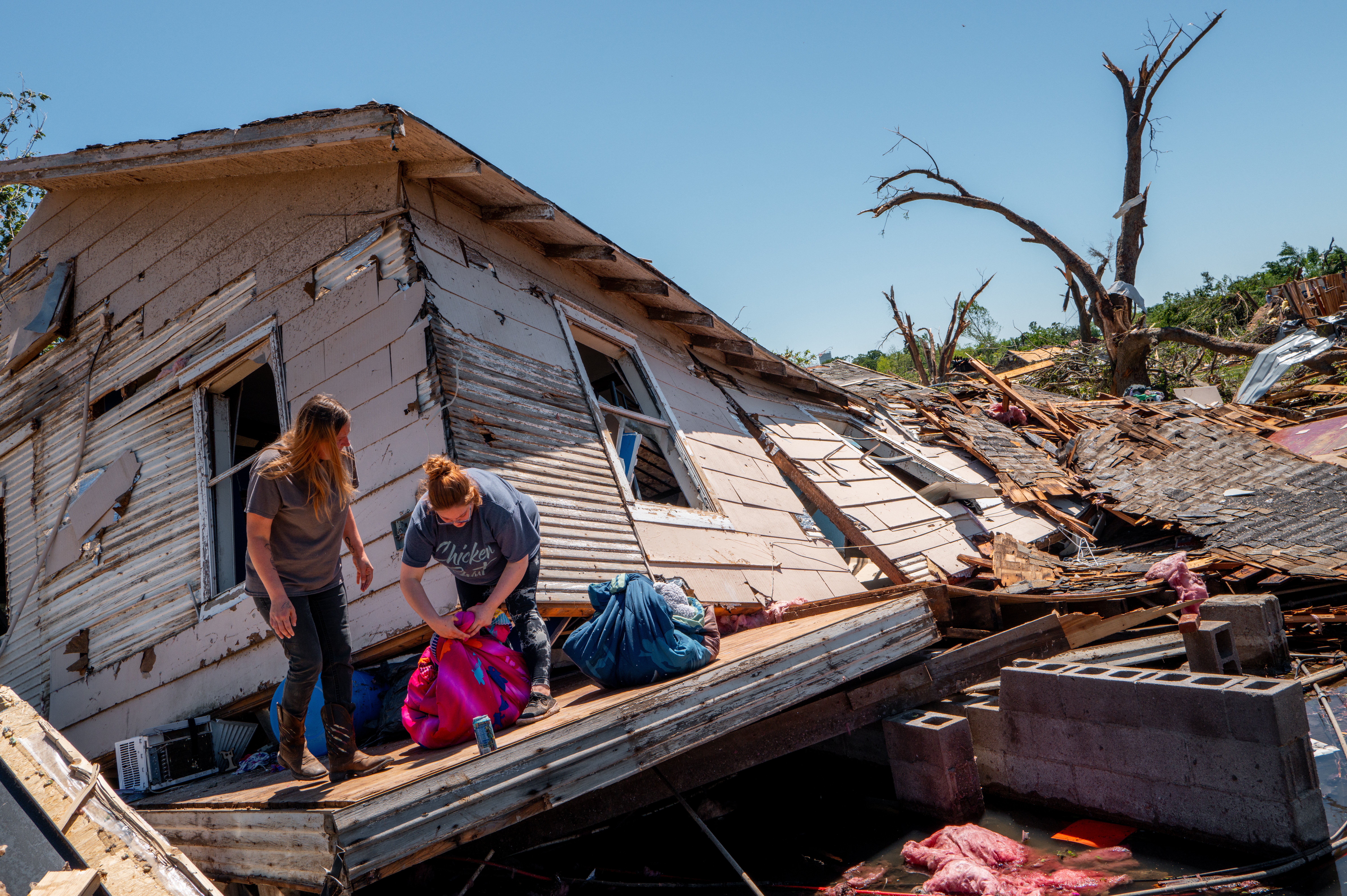 A family sift through and recover lost items after their home was struck by a tornado
