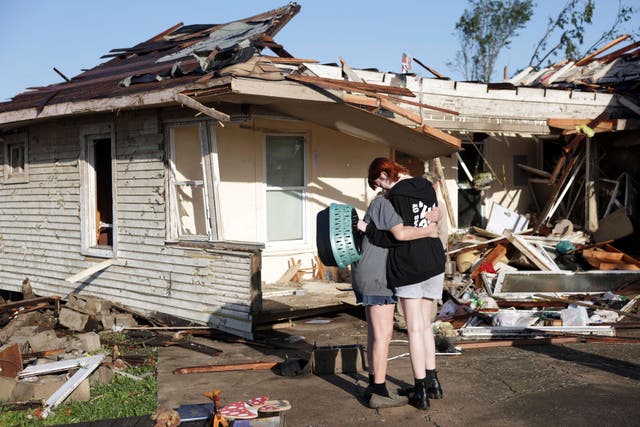 <p>Joy King, left, and her granddaughter Crystal Maxey hug in front of King's house that was destroyed by a tornado </p>