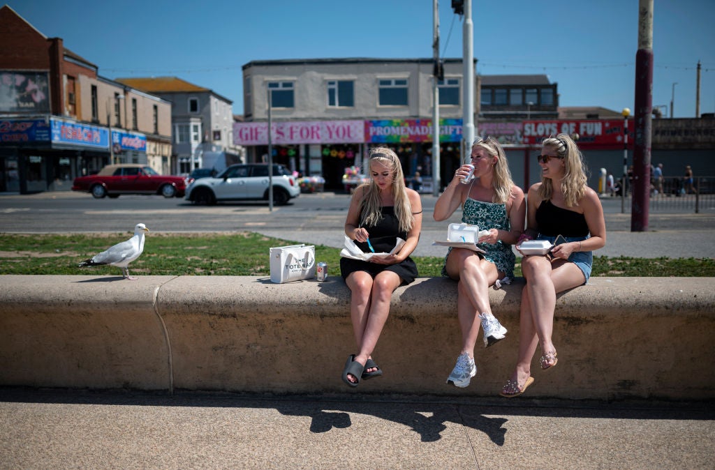 People enjoy the sunshine on the beach in Blackpool, north west England