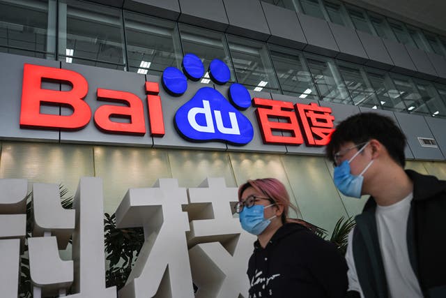 <p>People walk past a Baidu logo outside the company headquarters in Beijing on 2 February 2024</p>