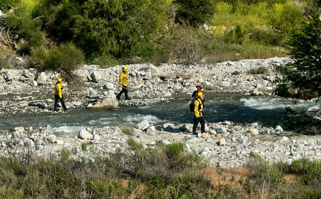 <p>San Bernardino County Fire Department officials conduct a swift water rescue of two children on Tuesday in California </p>