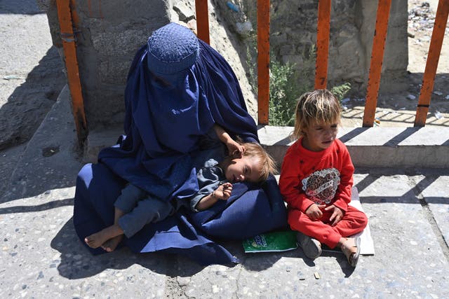 <p>A woman with her children begs for alms in Kabul </p>