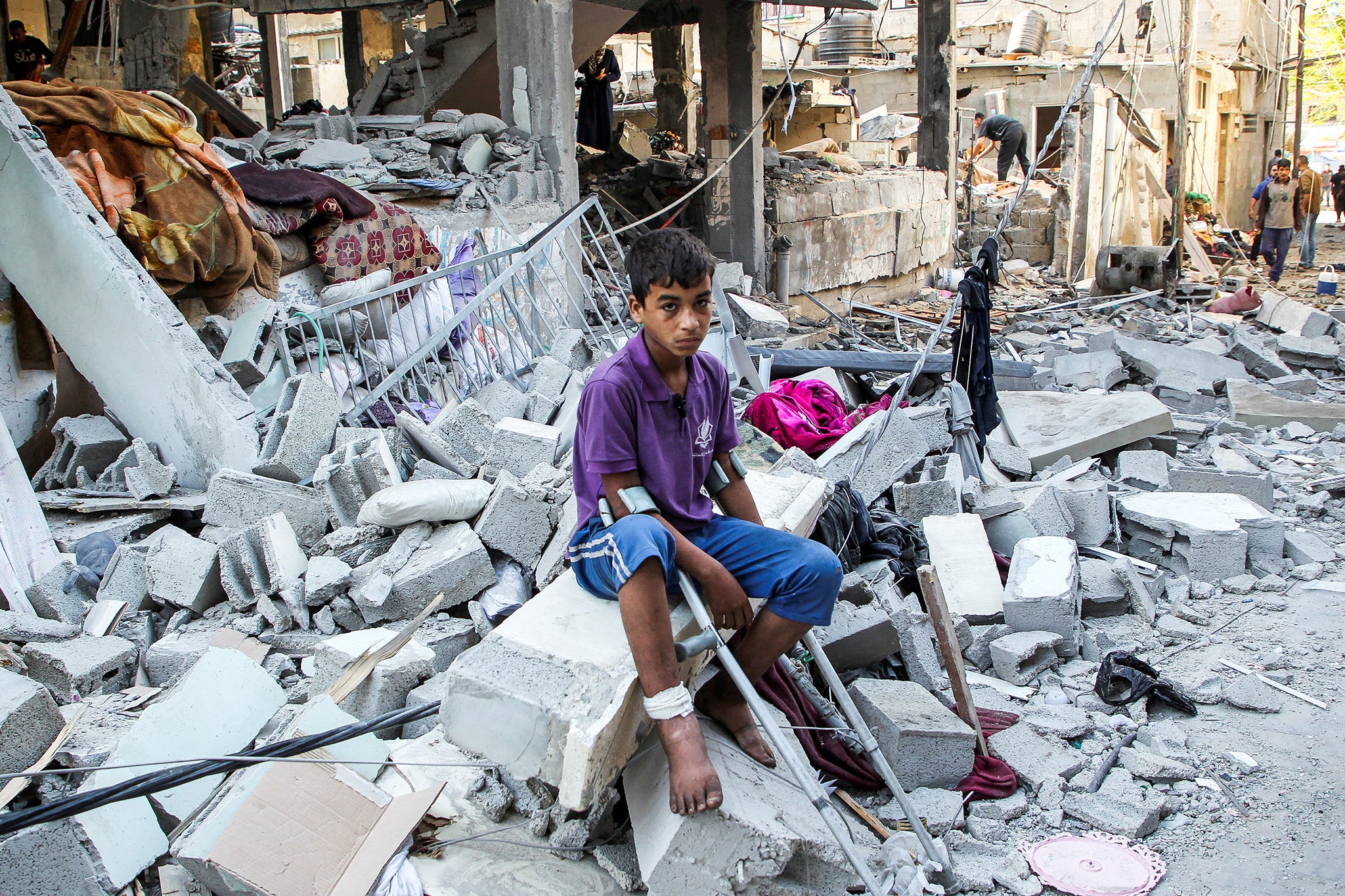 A wounded Palestinian sits on debris at the site of an Israeli strike on a house in Rafah