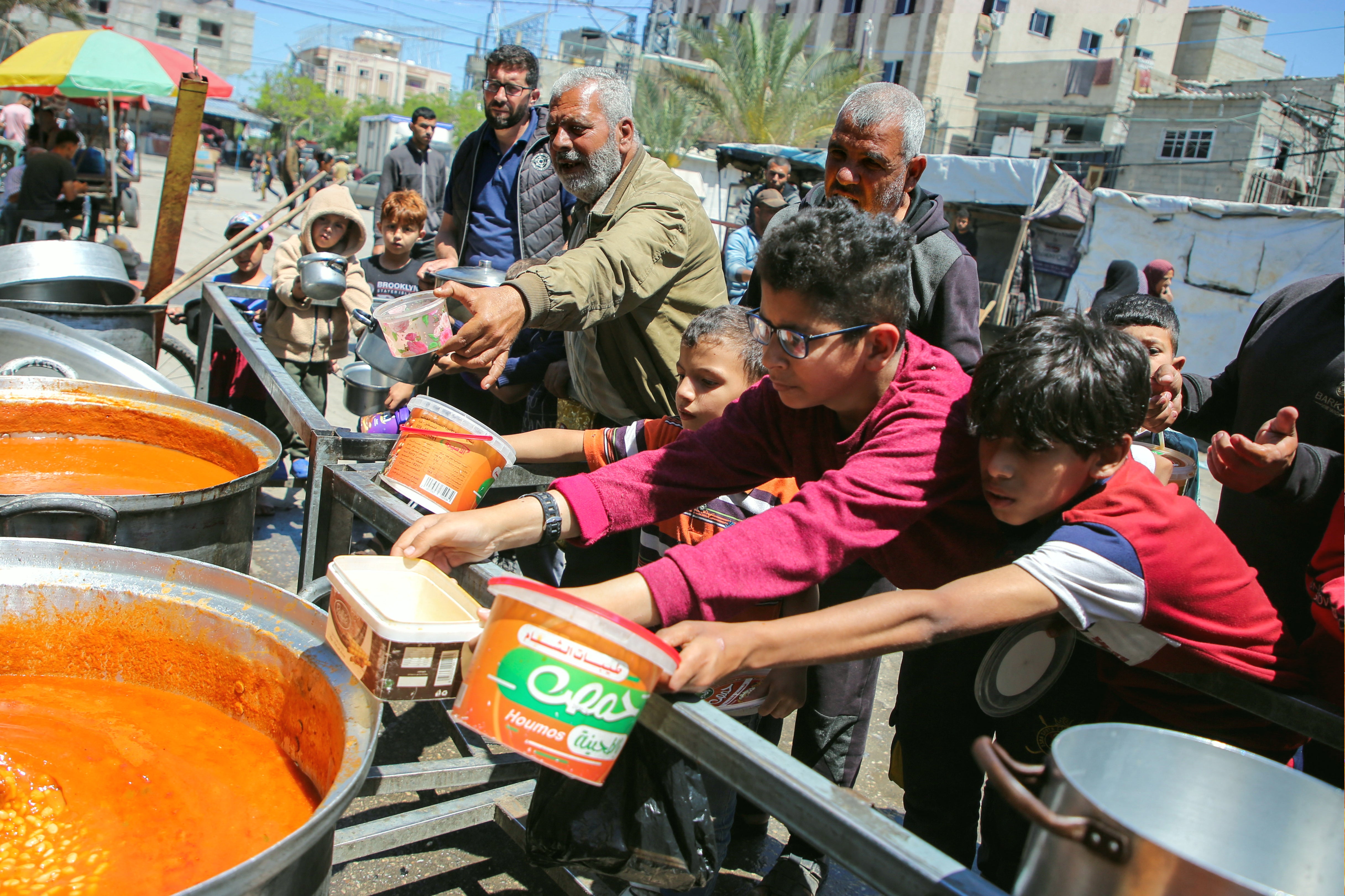 Palestinians gather to receive food cooked by a charity kitchen, amid shortages of aid supplies, after Israeli forces launched a ground and air operation in the eastern part of Rafah.