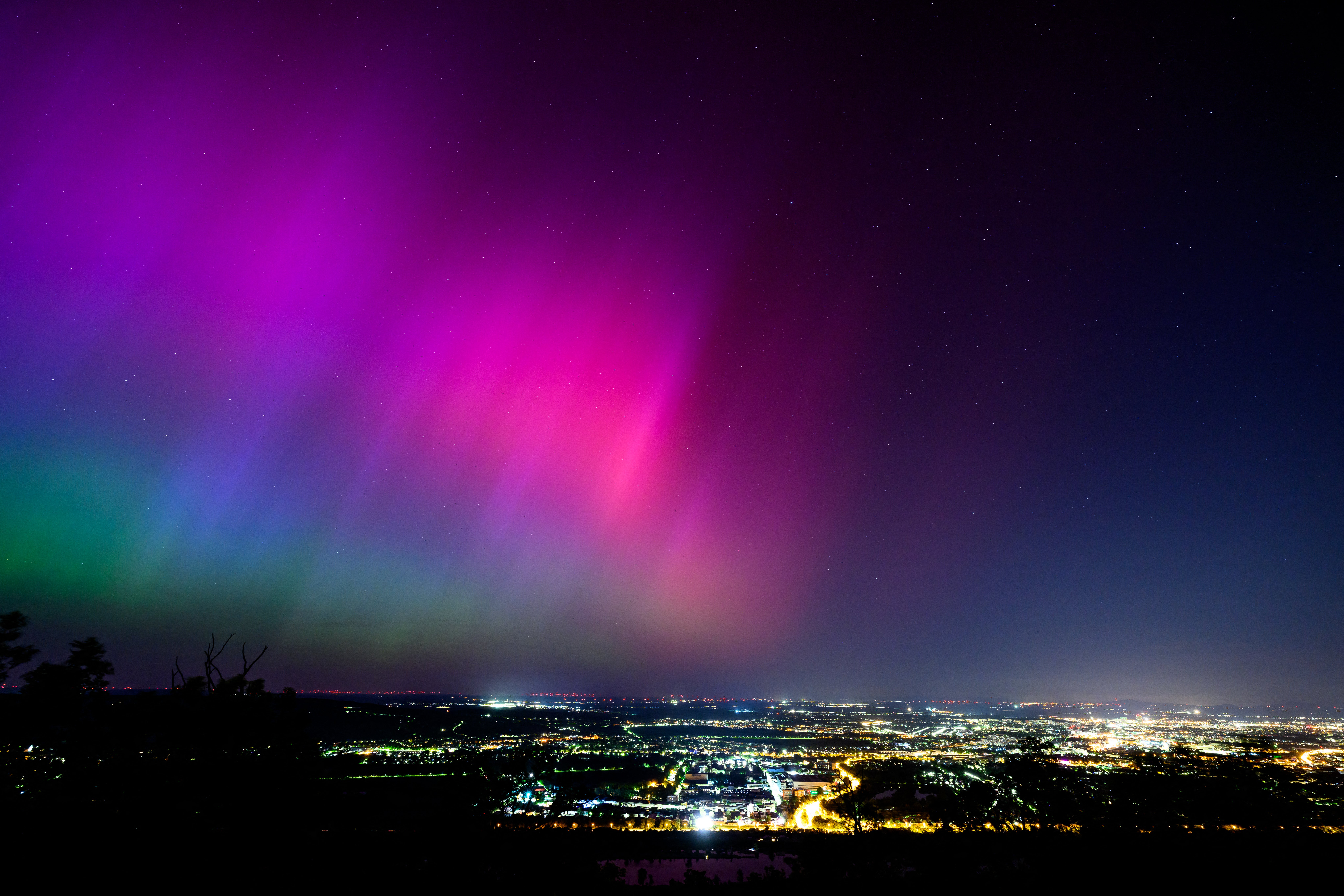 Northern lights or aurora borealis illuminate the night sky over Vienna during a geomagnetic storm on May 11, 2024