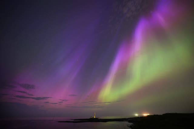 The aurora borealis glow in the sky over St Mary’s Lighthouse in Whitley Bay (Owen Humphreys/PA)