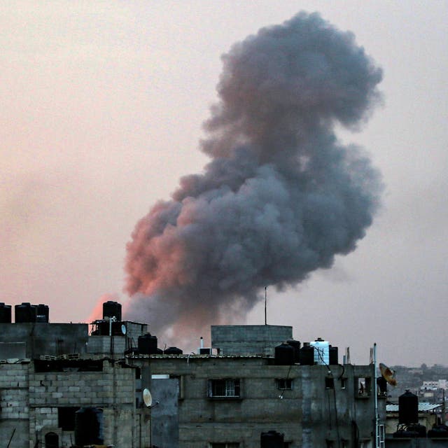 <p>Smoke rises above buildings during an early morning Israeli strike on Rafah in the southern Gaza Strip on 11 May </p>