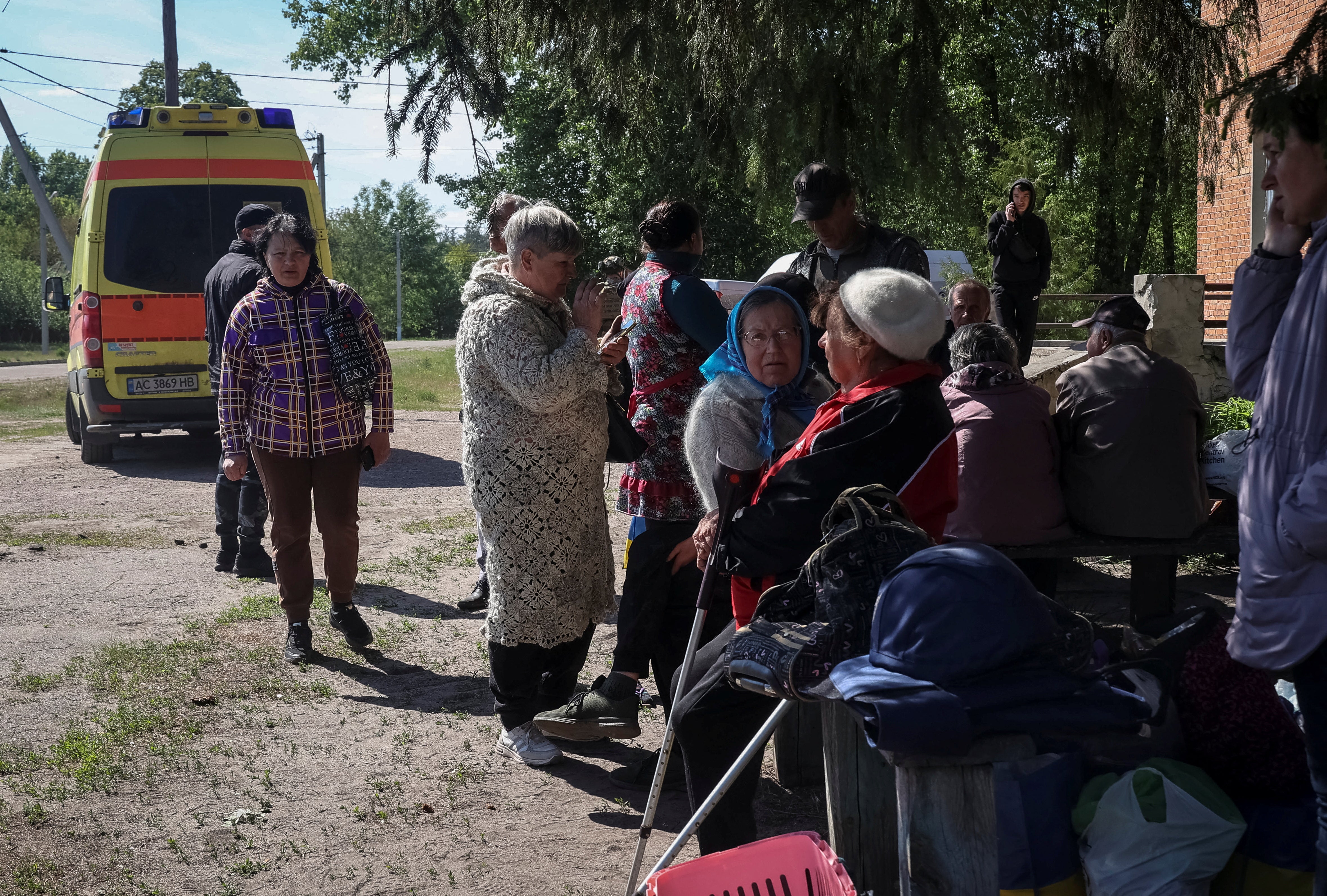 Residents from Vovchansk and nearby villages wait for buses amid an evacuation to Kharkiv