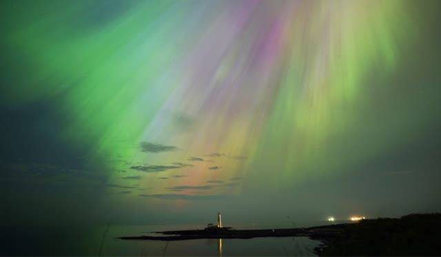<p>The aurora borealis, also known as the northern lights, glow in the sky over St Mary’s Lighthouse in Whitley Bay on Friday </p>