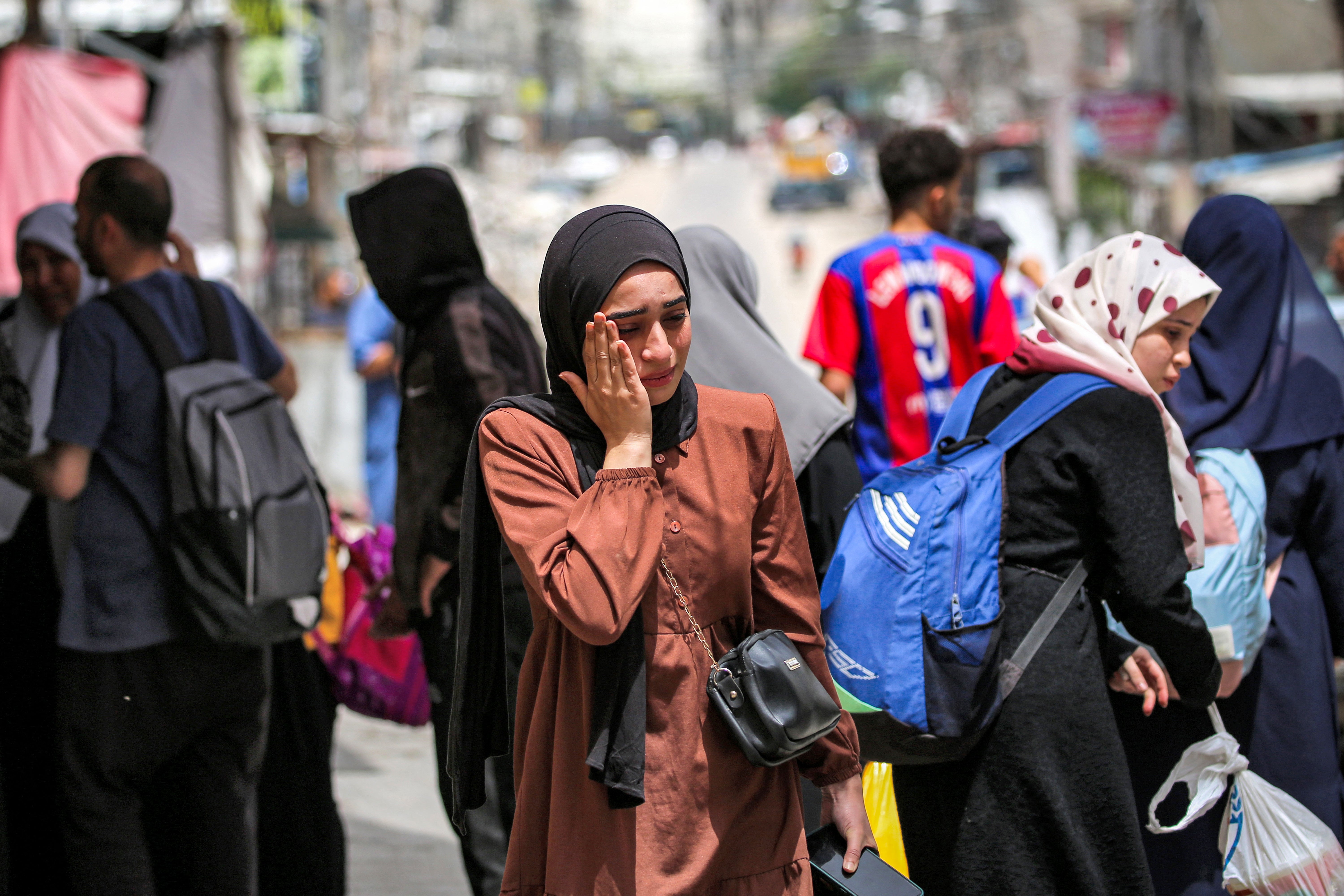 A woman wipes away tears before evacuating from Rafah in the southern Gaza Strip