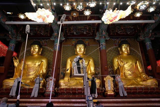 <p>Buddhists monks clean Buddha statues ahead of the upcoming birthday of Buddha on May 15, at the Jogye temple in Seoul</p>