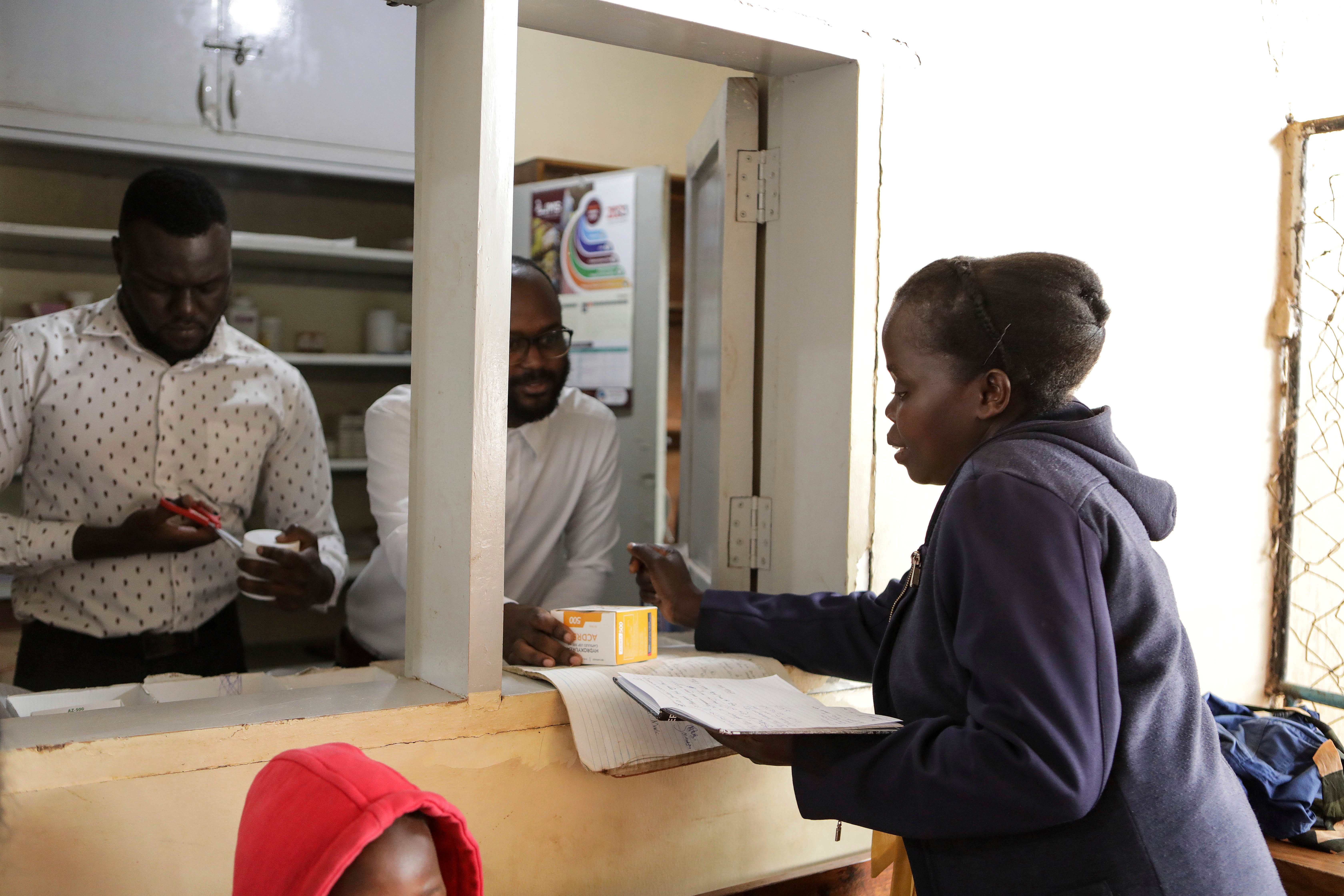 Barbara Nabulo picks her sickle cell prescription at the Mbale Regional Referral Hospital pharmacy counter, in Mbale, Uganda