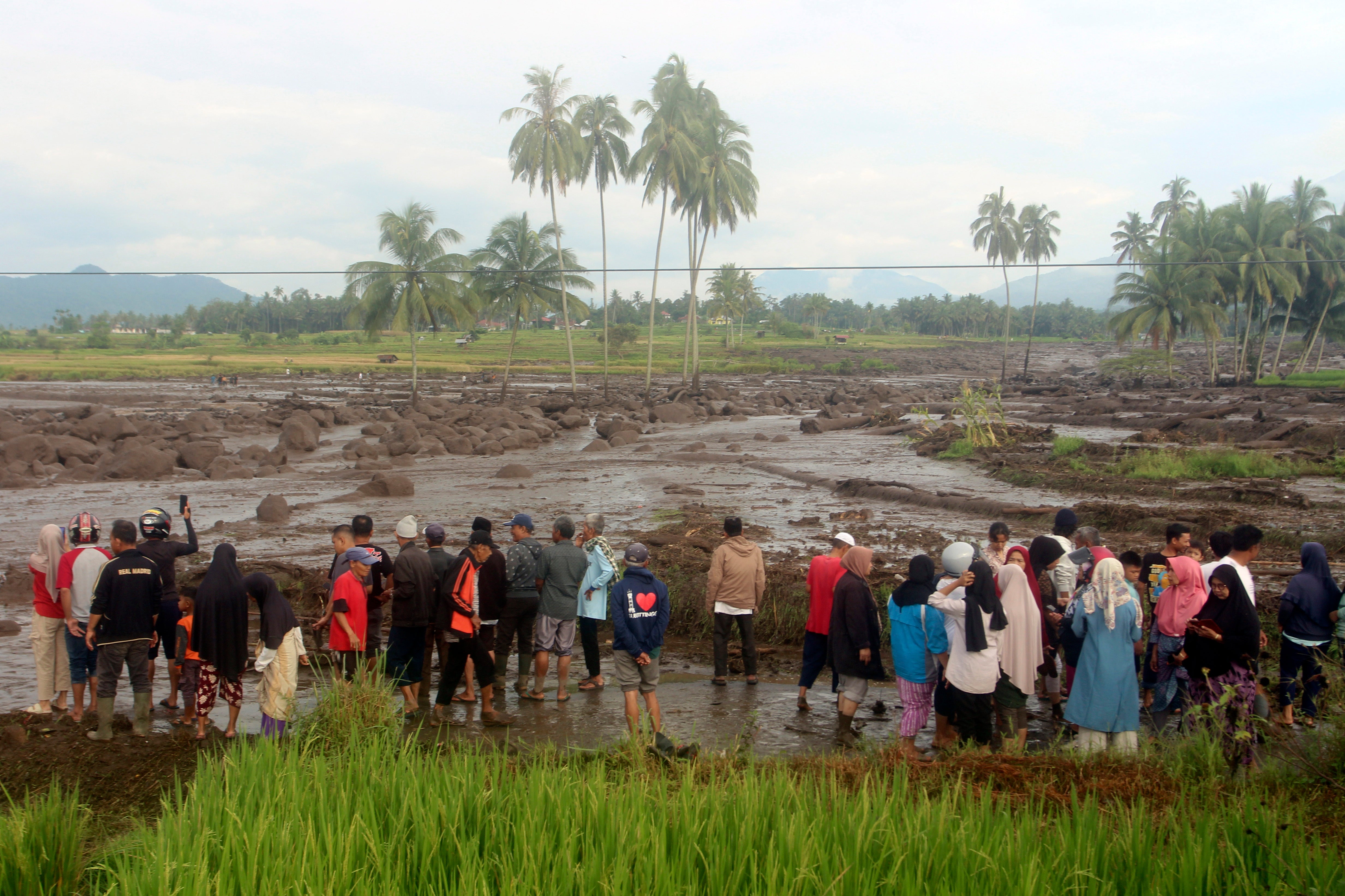People inspect an area affected by the flash flood that killed a number of people in Agam, West Sumatra, Indonesia, Sunday, 12 May 2024
