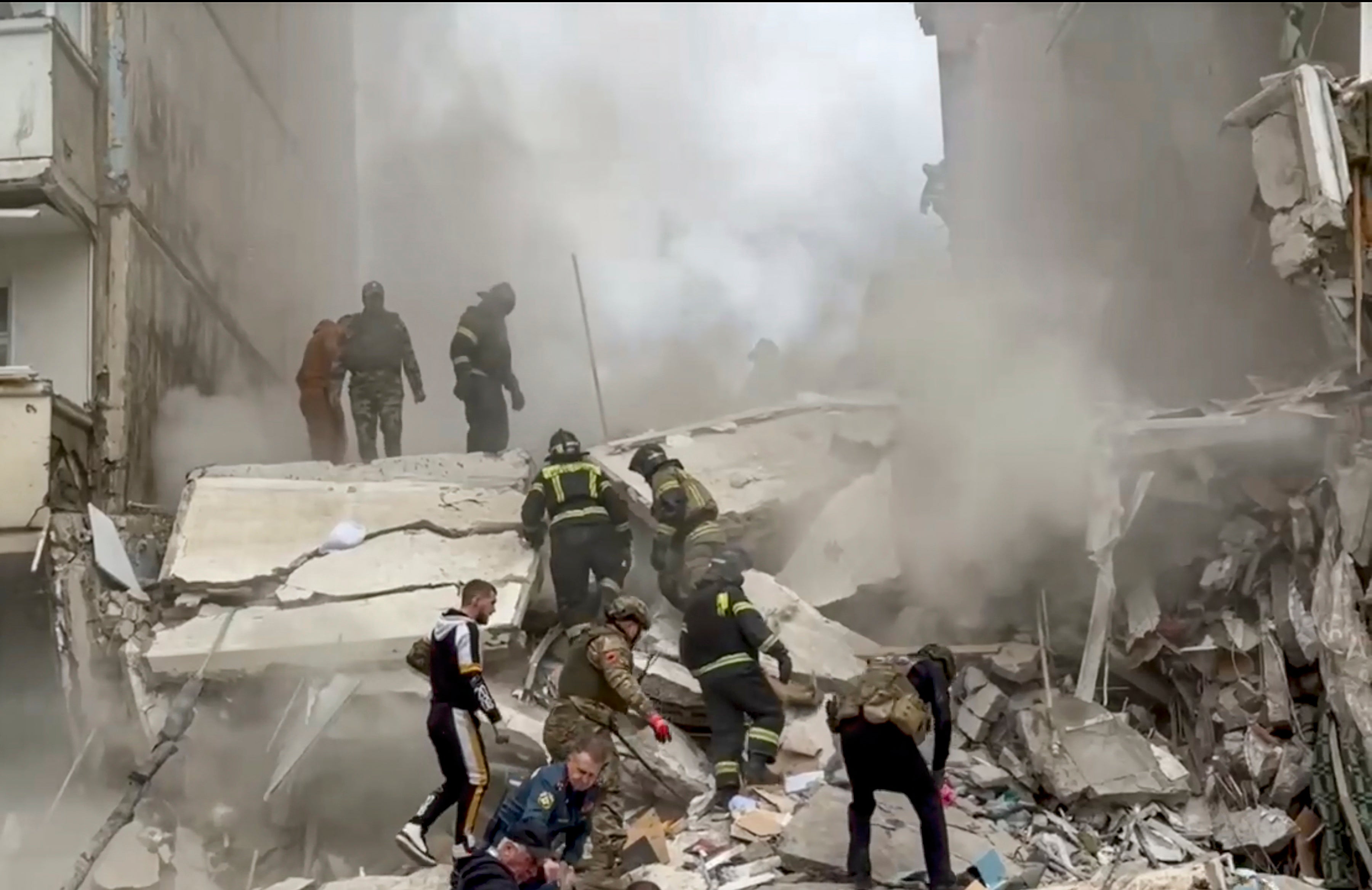 Russian rescuers search for survivors in the rubble after the roof of a destroyed apartment block in Belgorod collapsed onto emergency workers