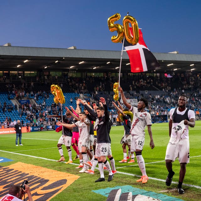 Bayer Leverkusen’s players celebrate 50 undefeated matches in a row after victory at Bochum (David Inderlied/dpa via AP)