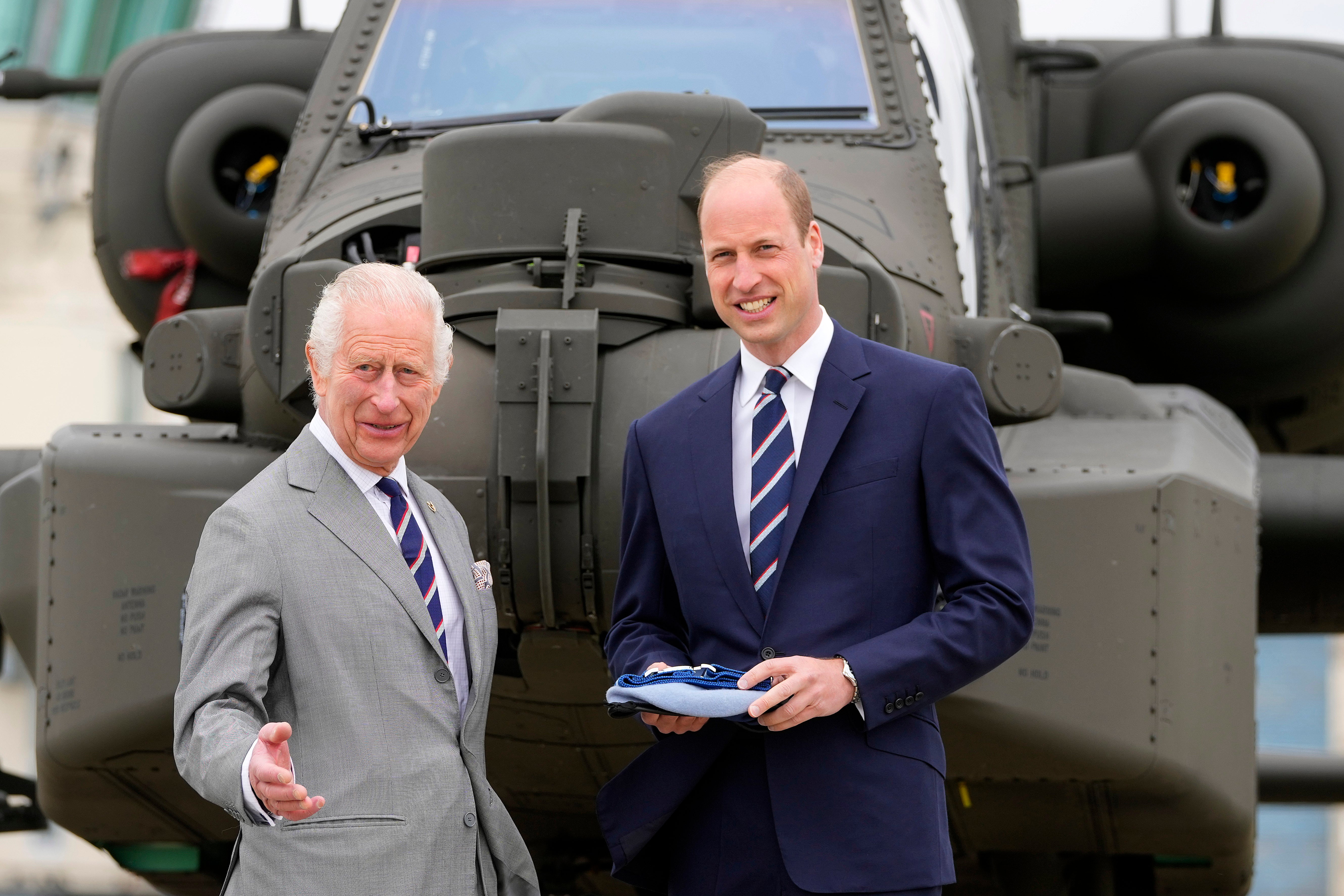 Charles and William in front of an Apache helicopter at the Army Aviation Centre on 13 May