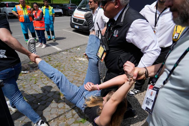 A climate activist is removed by security staff after two matches at the Italian Open were suspended (Andrew Medichini/AP