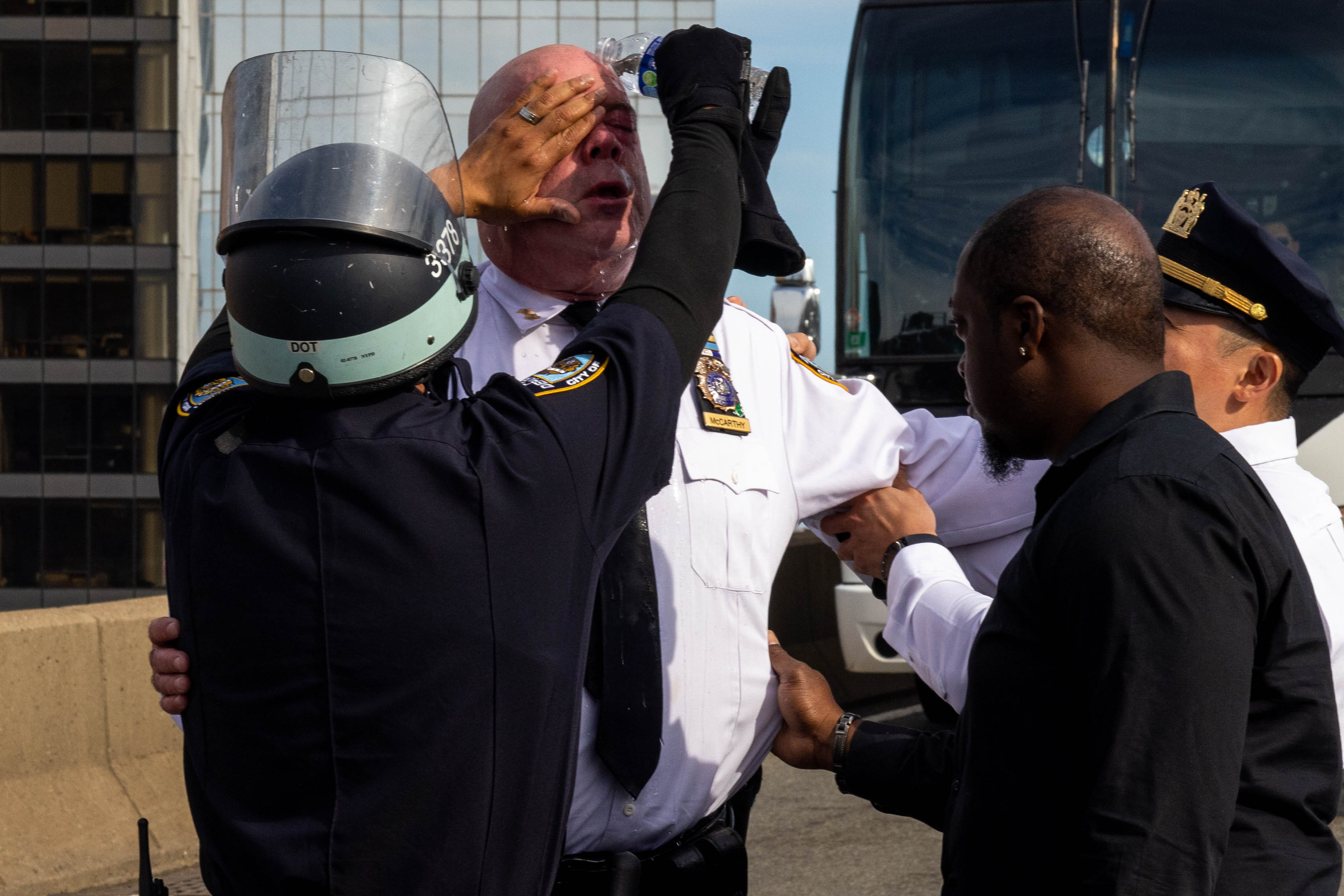 James McCarthy, NYPD assistant chief, is assisted after seemingly being affected by a chemical irritant as police arrest pro-Palestinian demonstrators blocking traffic on the Manhattan Bridge