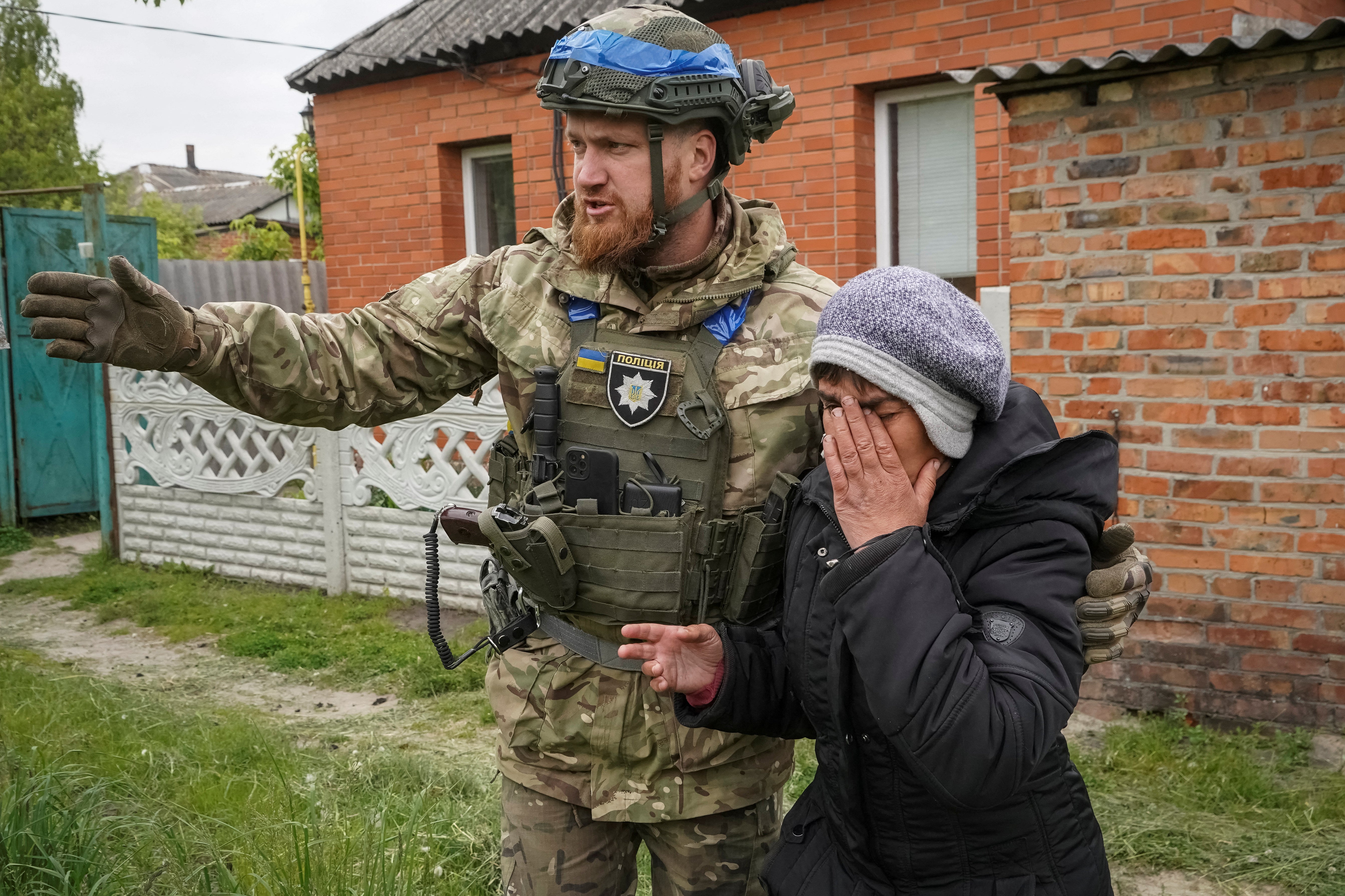 A police officer helps a local resident during an evacuation to Kharkiv from Vovchansk – one of the towns liberated from Russian occupation in 2022