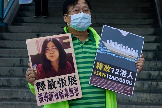 <p>File. An activist holds a picture of Zhang Zhan outside the Chinese central government’s liaison office in Hong Kong on 28 December 2020</p>