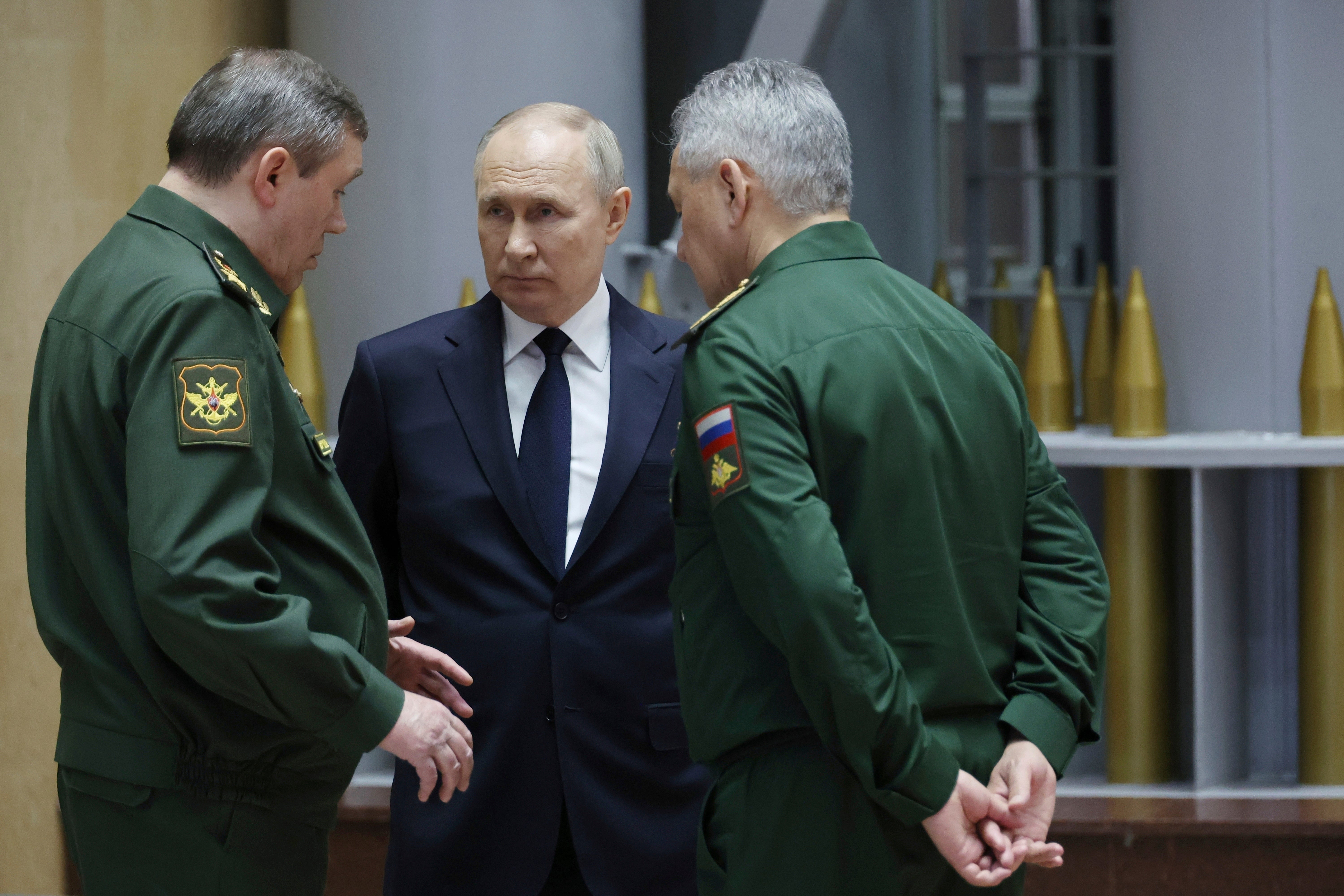 Russian President Vladimir Putin, center, talks with Russian Chief of General Staff Gen. Valery Gerasimov, left, and Russian Defense Minister Sergei Shoigu after a meeting with military leaders in Moscow, Russia,