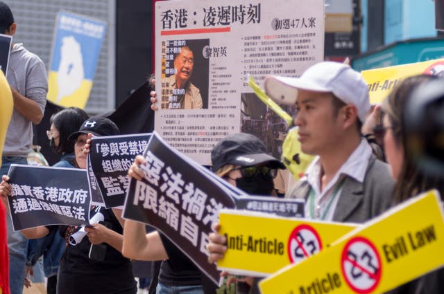 <p>People from Hong Kong living in Taiwan display placards and a poster showing Jimmy Lai during a protest in Taipei</p>