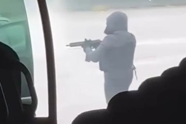 <p>A gunman points an assault rifle at the prison convoy </p>
