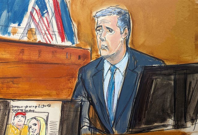 <p>Michael Cohen testifies as a Wall Street Journal article is displayed on a screen in Manhattan criminal court on Tuesday, 14 May 2024</p>