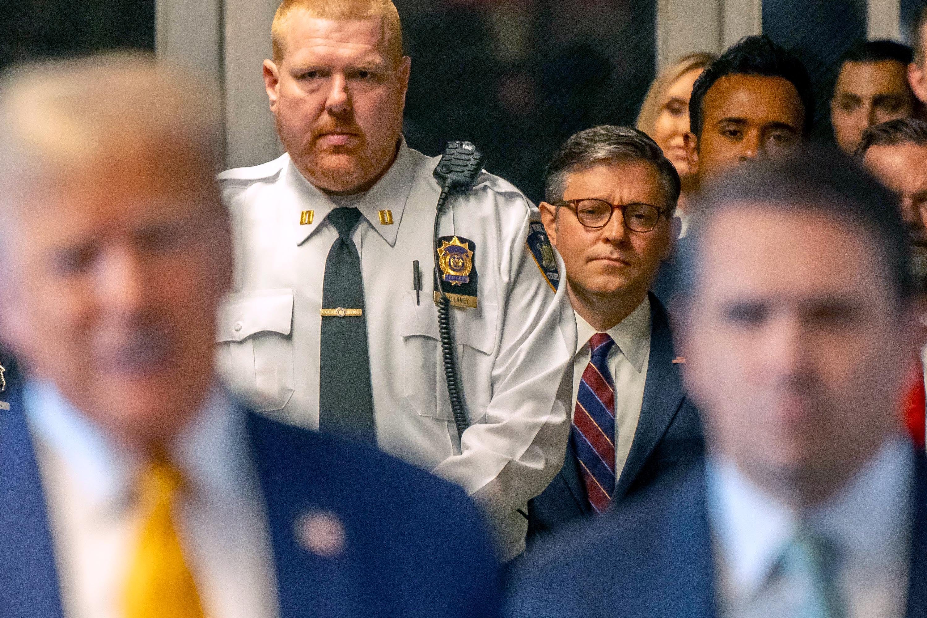 US Speaker of the House Mike Johnson (R-LA) listens as former U.S. President Donald Trump speaks to the media as he arrives with attorney Todd Blanche (R) to court during his trial for allegedly covering up hush money payments